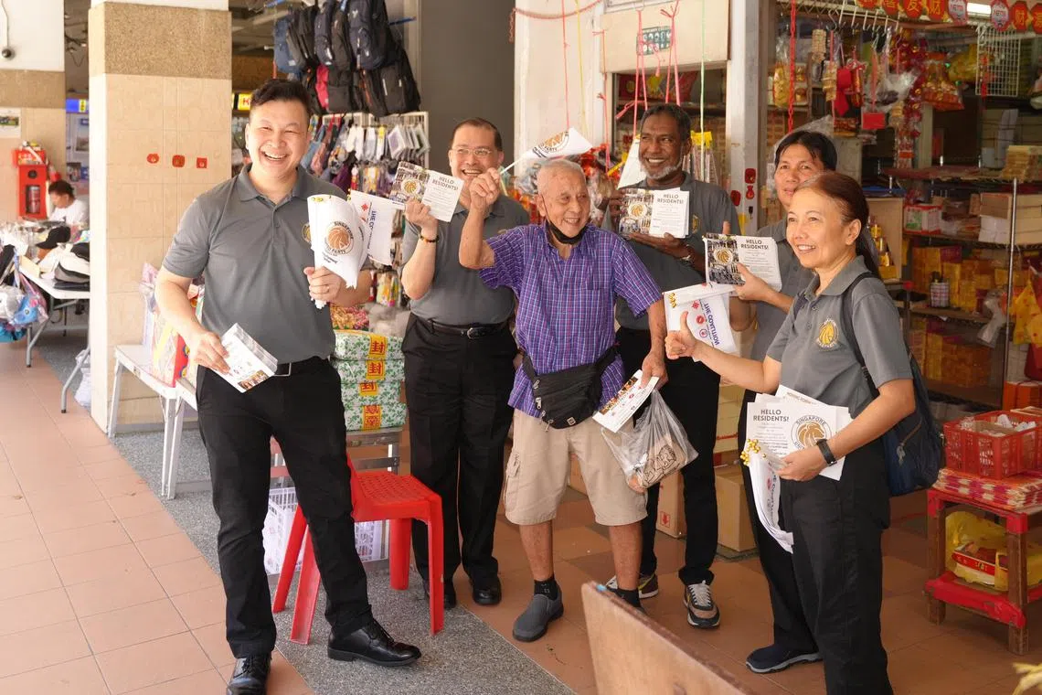 统一党秘书长朱来成（左）与党员黄健源（后排左起）、党主席厉督湾、党员叶进宝和诺莱尼走访宏茂桥一道的德义阁熟食中心和附近商店，分发传单。（谢智扬摄）