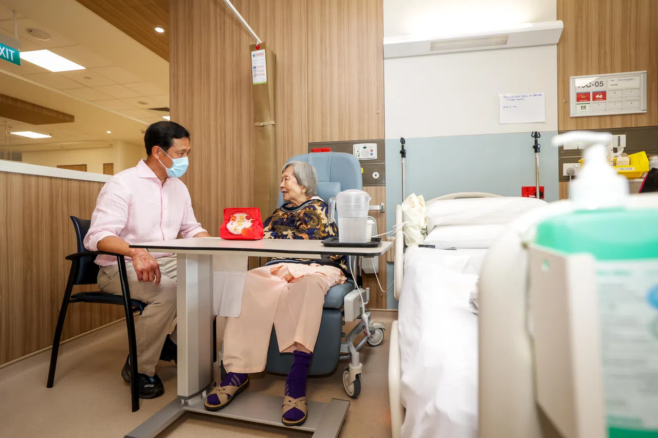 卫生部长王乙康（左）大年初一到新加坡中央医院和欧南社区医院的病房探望病患，给他们派发年柑。（叶振忠摄）