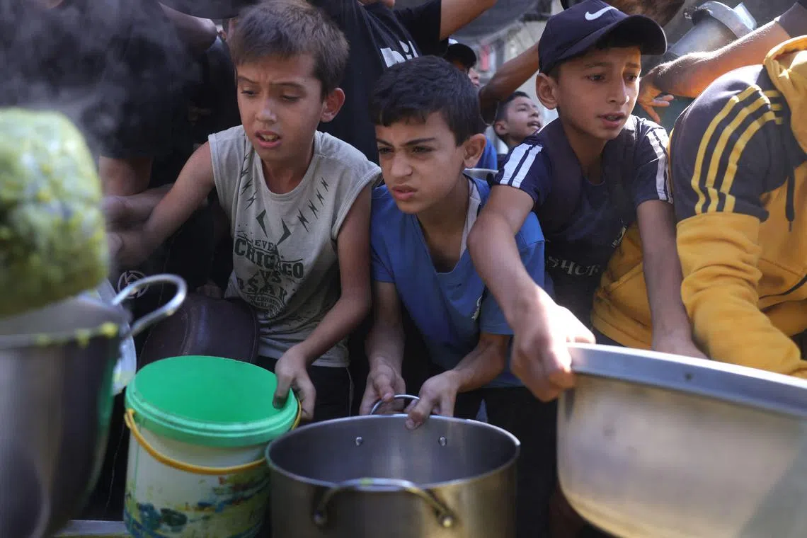6月27日，巴勒斯坦民众在加沙市一处食品分发点排队领取热餐。（法新社）