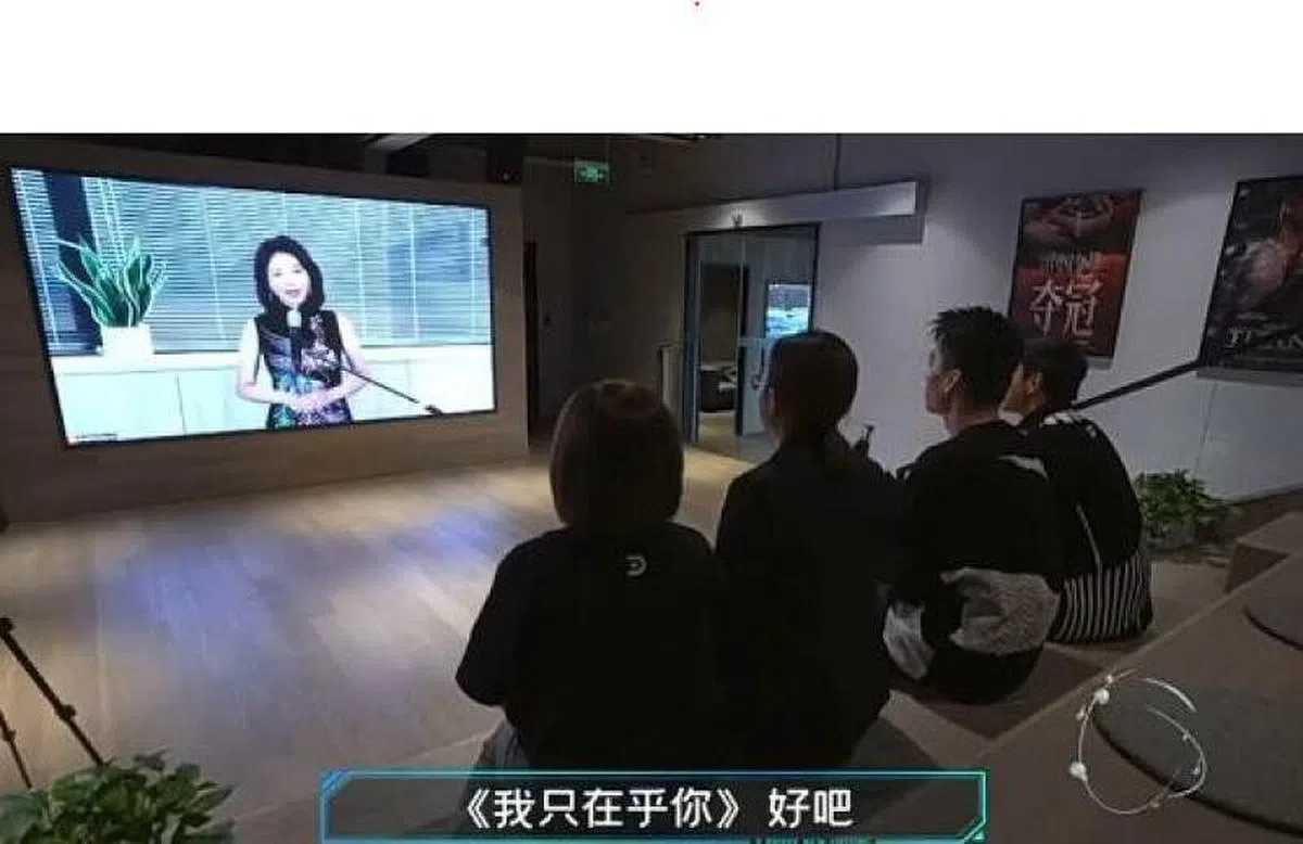 邓丽君“复活”现身大荧幕，荧幕前坐着几位年轻观众。（网络）