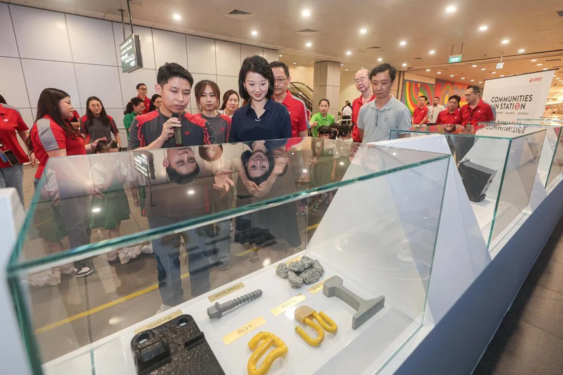 交通部兼国家发展部高级政务部长孙雪玲（身穿深蓝裙）星期五在海湾舫站参观展览，并听两名地铁工程师讲解不同部件的功能。（李冠卫摄）