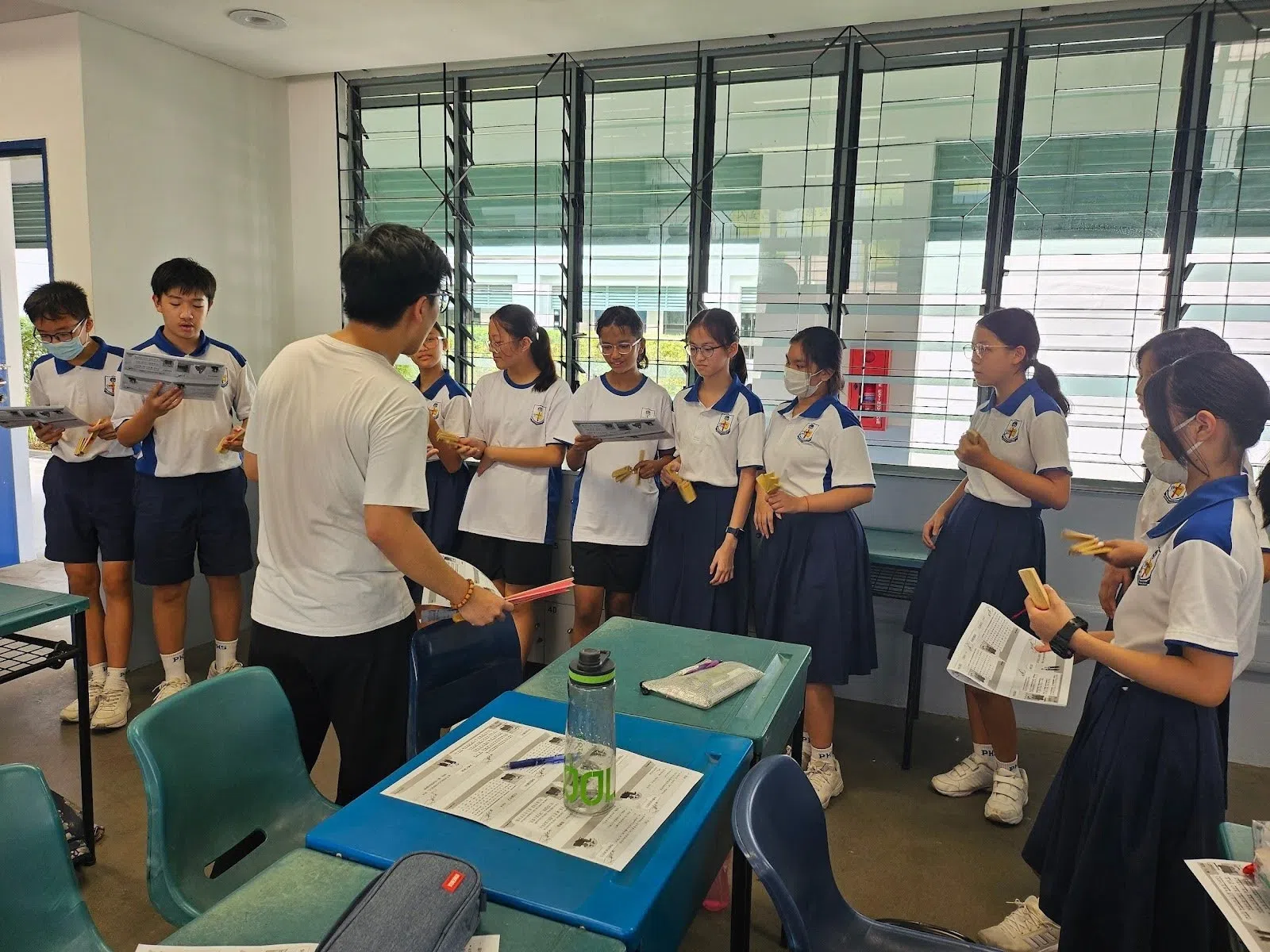 学生跟着指导老师用快板打节奏朗诵篇章。（长老会中学提供）