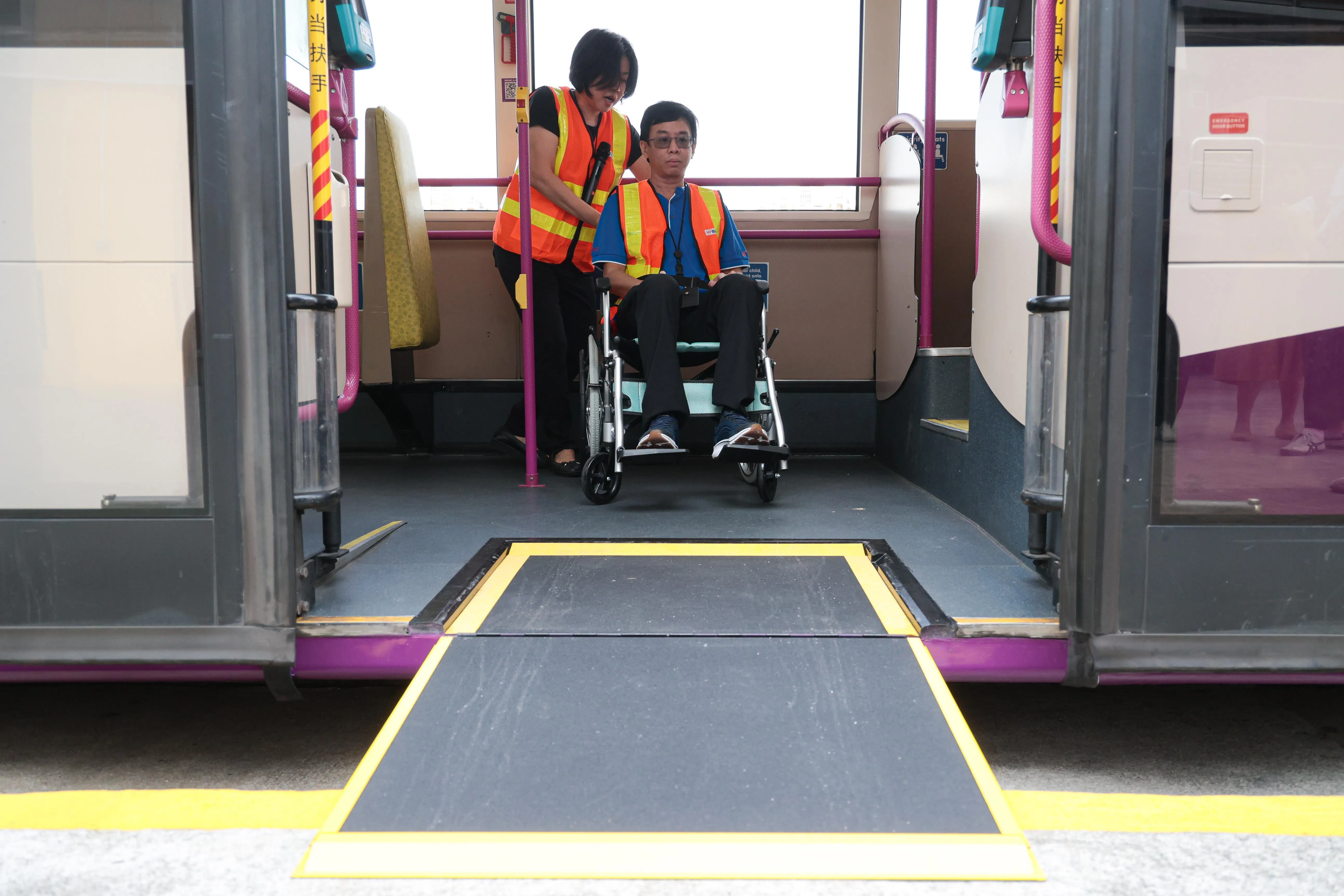 前线人员学习操作巴士斜坡板和掌控轮椅，并把轮椅使用者推到巴士中一个舒适位置，确保这名特需者能安全顺畅地上下车。（李冠卫摄）