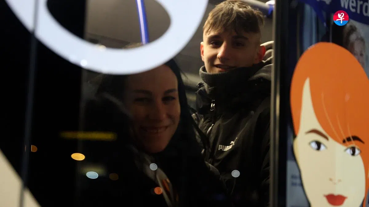 在离开的巴士上，爱德华和耶娜向记者挥手道别。（李健玮摄）