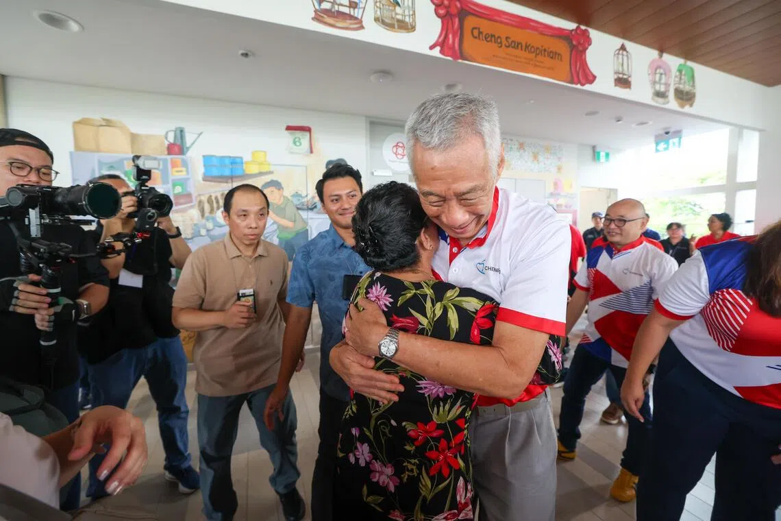 国务资政李显龙星期六上午出席翻新后的静山民众俱乐部开幕活动时，与居民热情拥抱。（白艳琳摄）