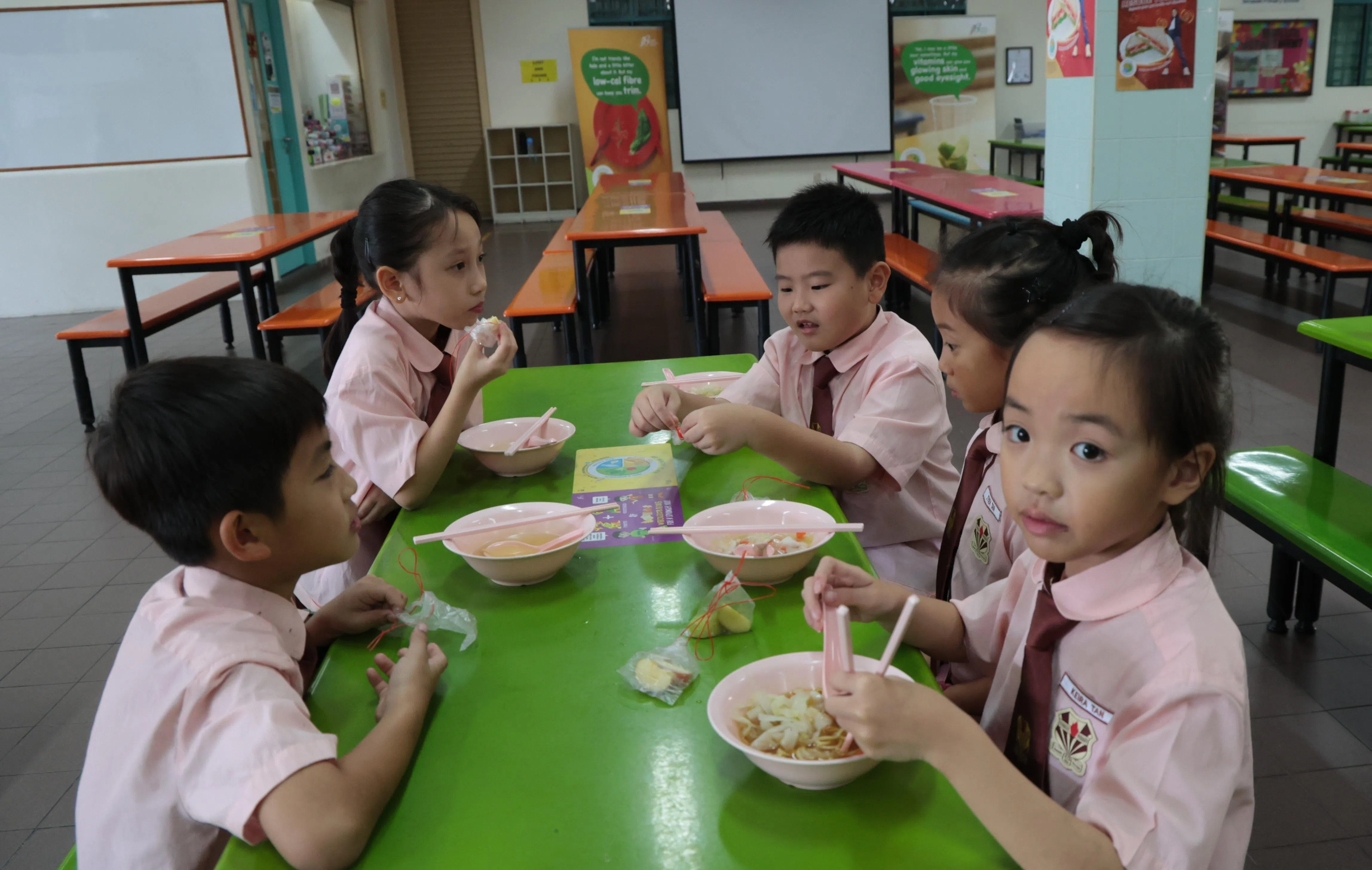 淡马锡小学生在食堂购买餐食时，会获得切片苹果。（梁麒麟摄）