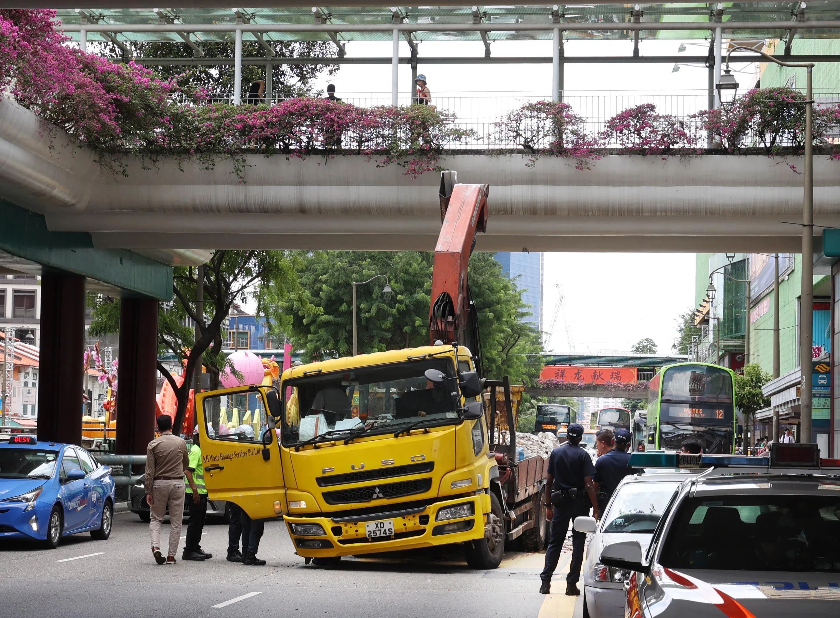 黄色罗厘的吊臂撞上行人天桥后，车头向一边倾斜。（档案照片）