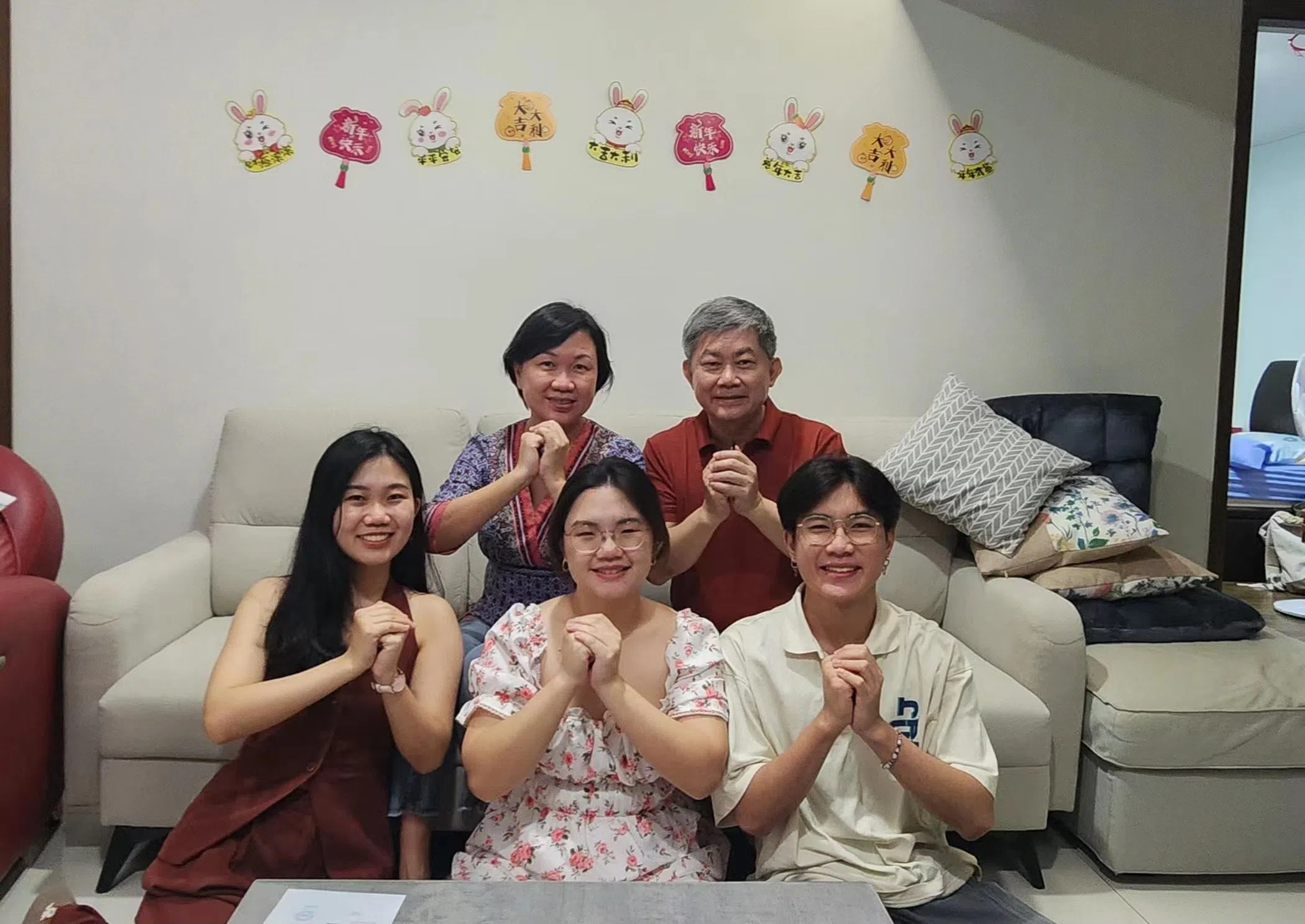 疫情期间聚会人数受限，吴世伟（后排右）一家五口拍下拜年照片，通过群组聊天软件向亲人拜年。（受访者提供）