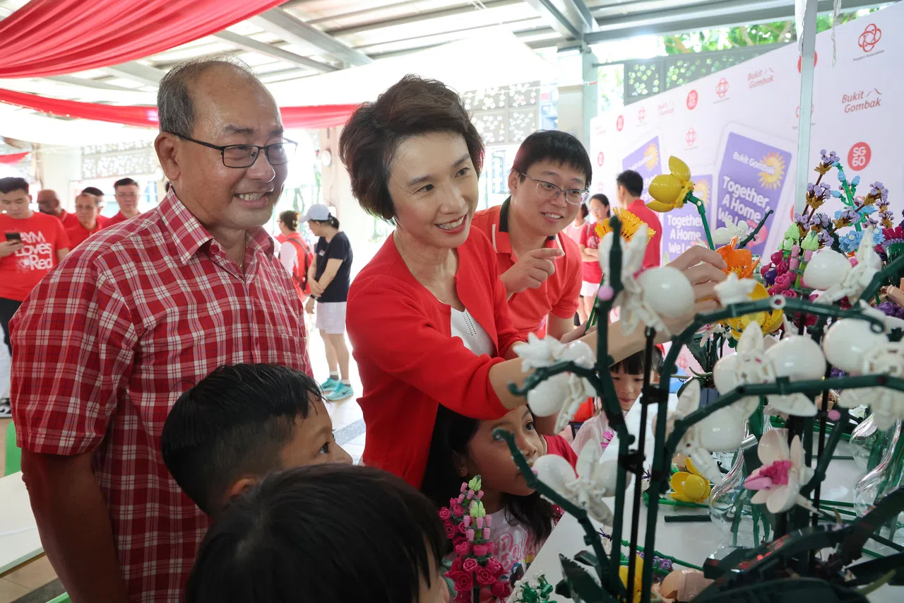 贸工部兼文化、社区及青年部高级政务部长刘燕玲（中），欣赏武吉甘柏居民制作的乐高花卉。（唐家鸿摄）