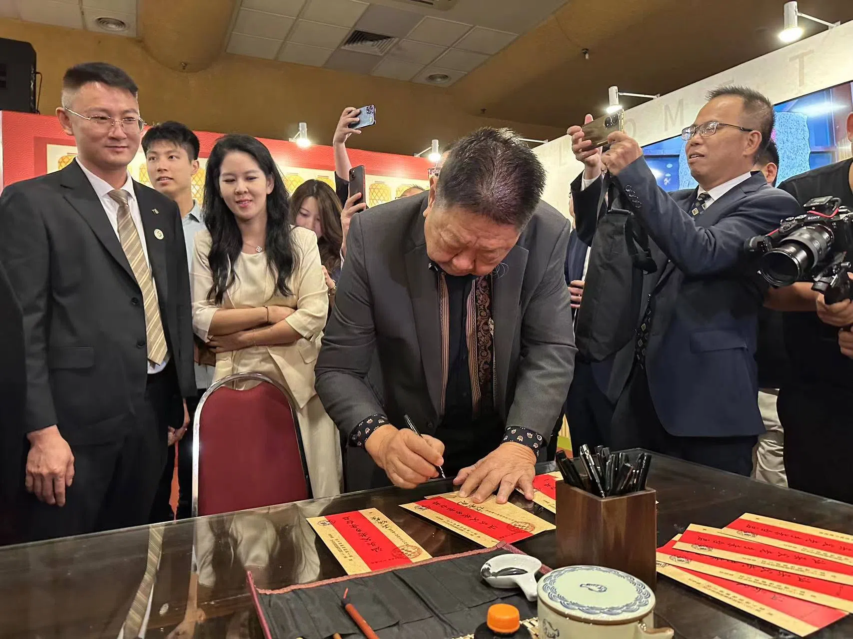 马来西亚潮州公会联合会总会长林家光在现场写批。