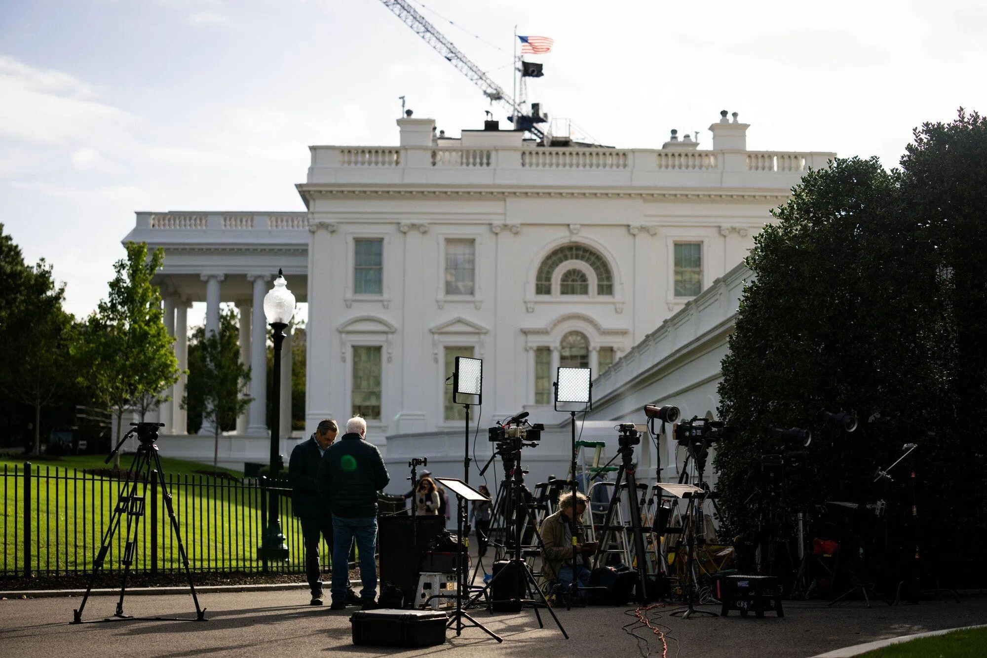 尽管CNN、MS NOW和Politico记者在星期四（9月24日）获法院恢复采访资格，却仍一度进不了白宫。图为部分媒体人员在白宫外架着电视摄像机。（彭博社）