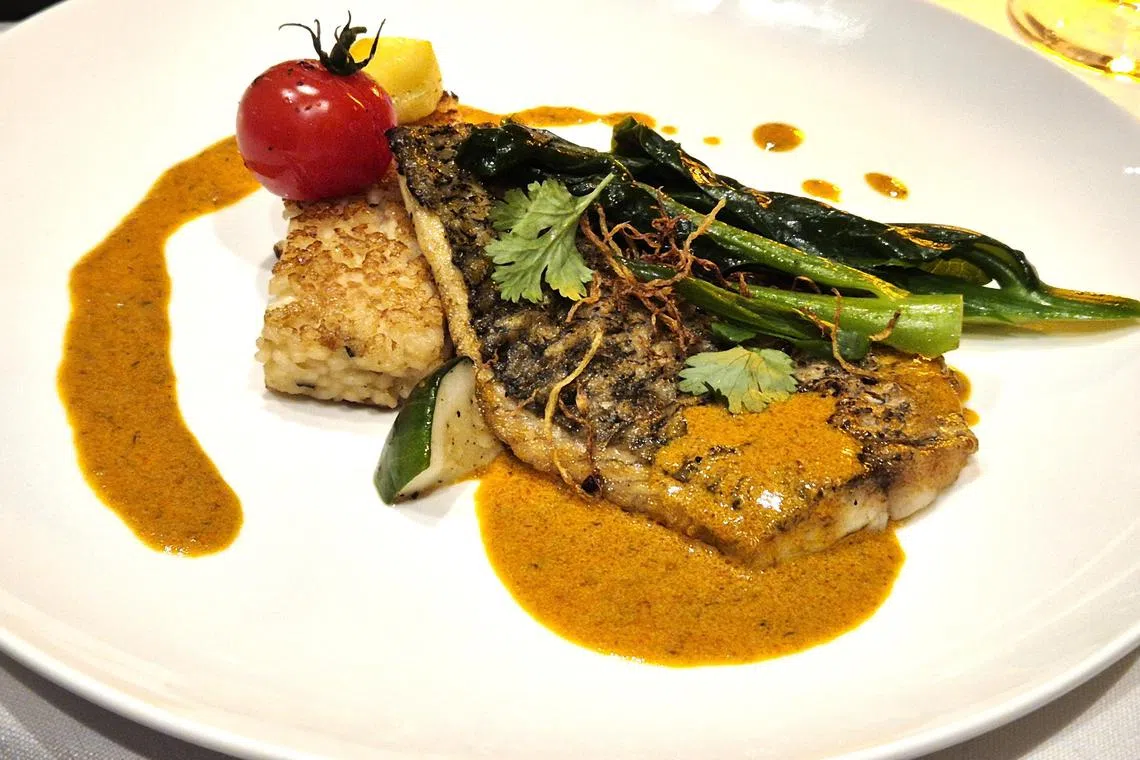 娘惹酱烤鲈鱼配搭姜丝芥兰和意大利烩饭烤饼。（陈爱薇摄）