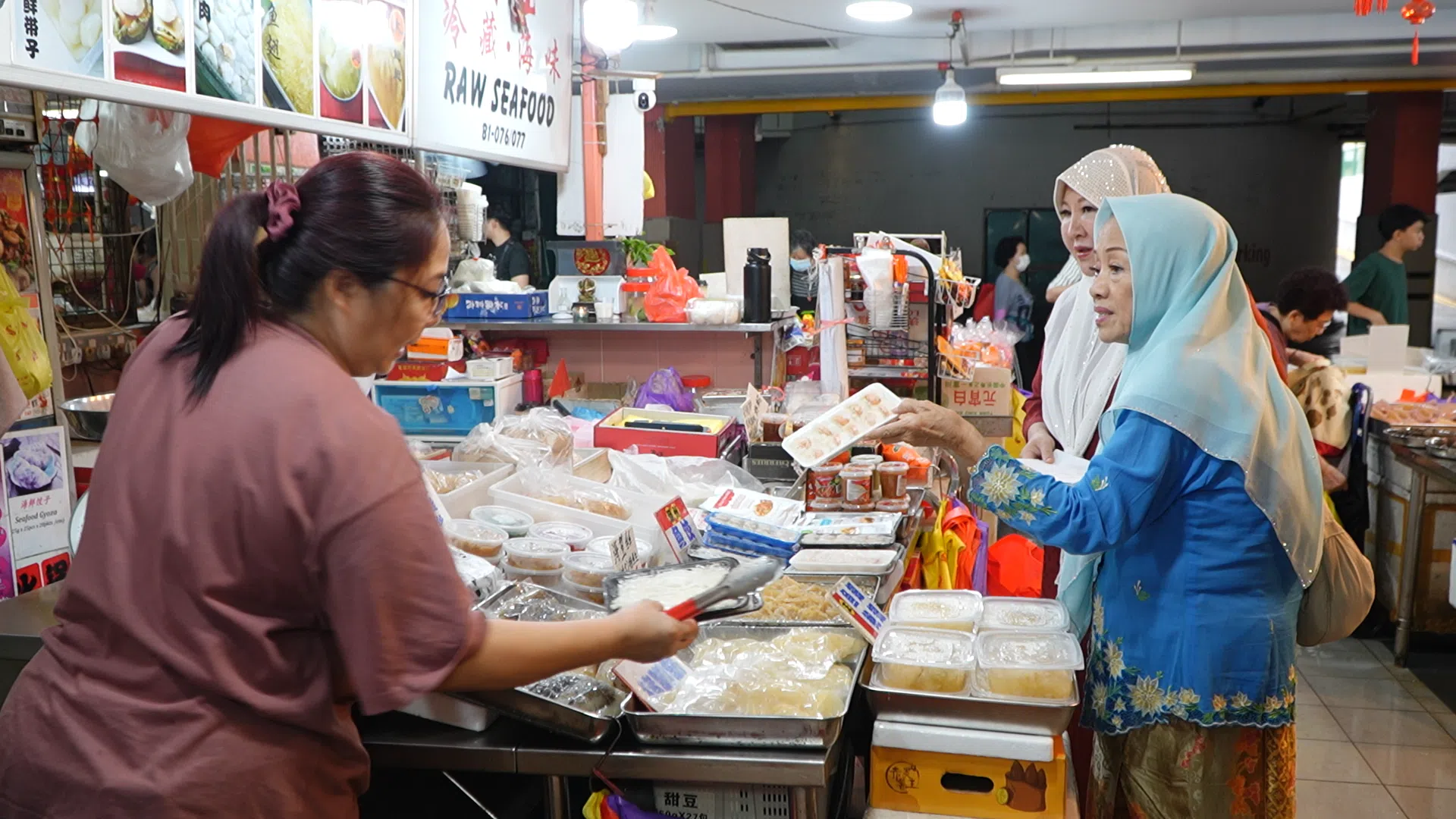 回回协会会长傅宝玉（右一）和负责新年聚会活动餐饮的海丽娟（右二）到市场采购食材。（视频截图）