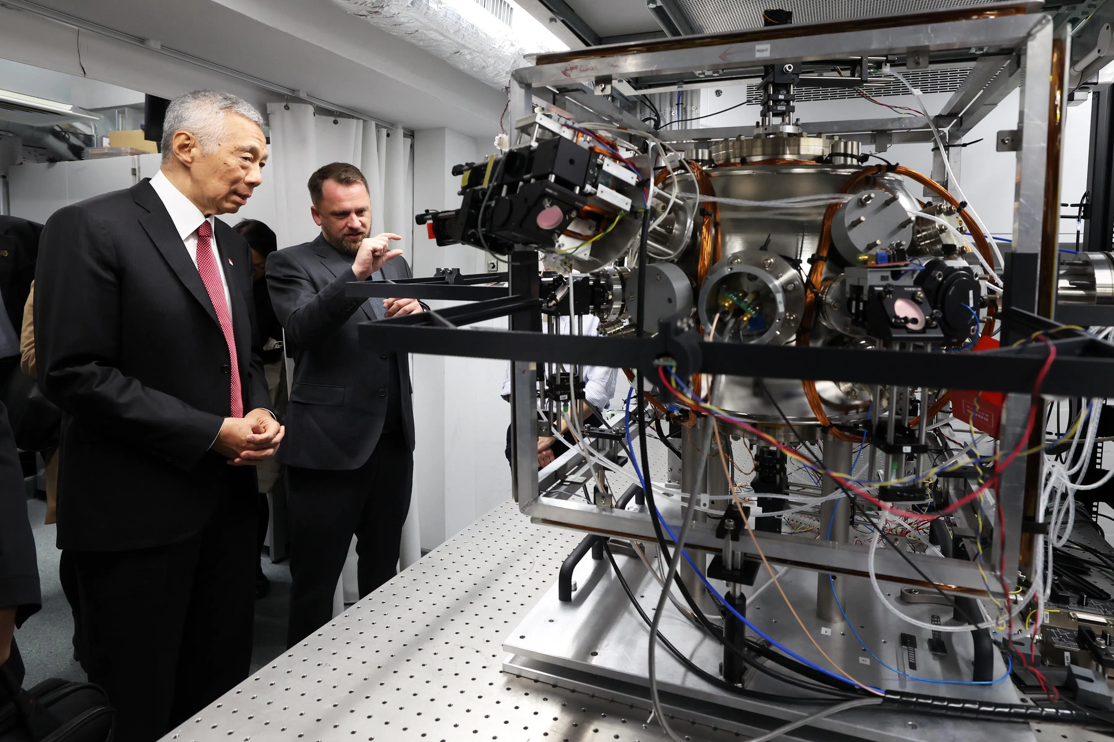 国务资政李显龙（左）星期二在伦敦帝国理工学院实验室观看量子导航演示。实验室使用自主研发的量子传感器，即使没有全球定位系统（GPS），也能精准指引方向。（数码发展及新闻部提供）