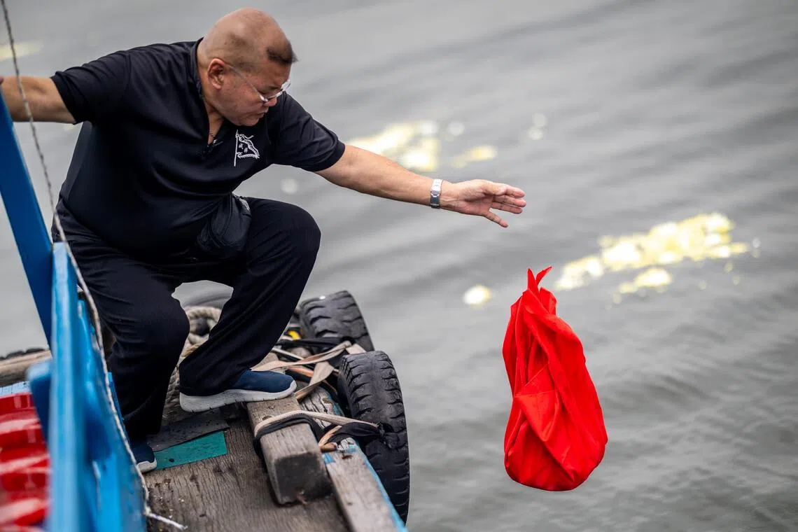 骨灰随裹布缓缓散入海中，随浪花流逝。（叶振忠摄）