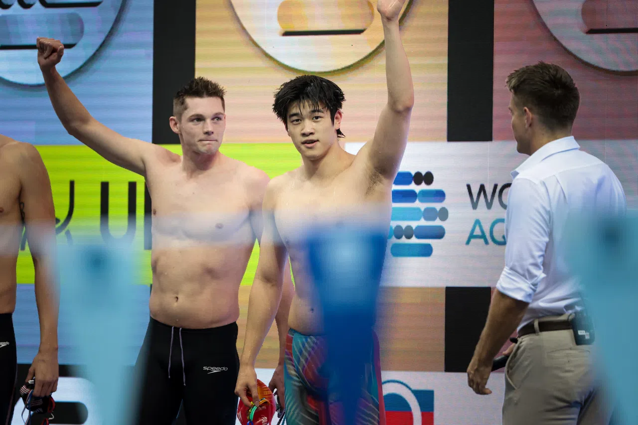 中国百米自由泳奥运冠军潘展乐（右）结束比赛后向观众挥手。（张俊杰摄）