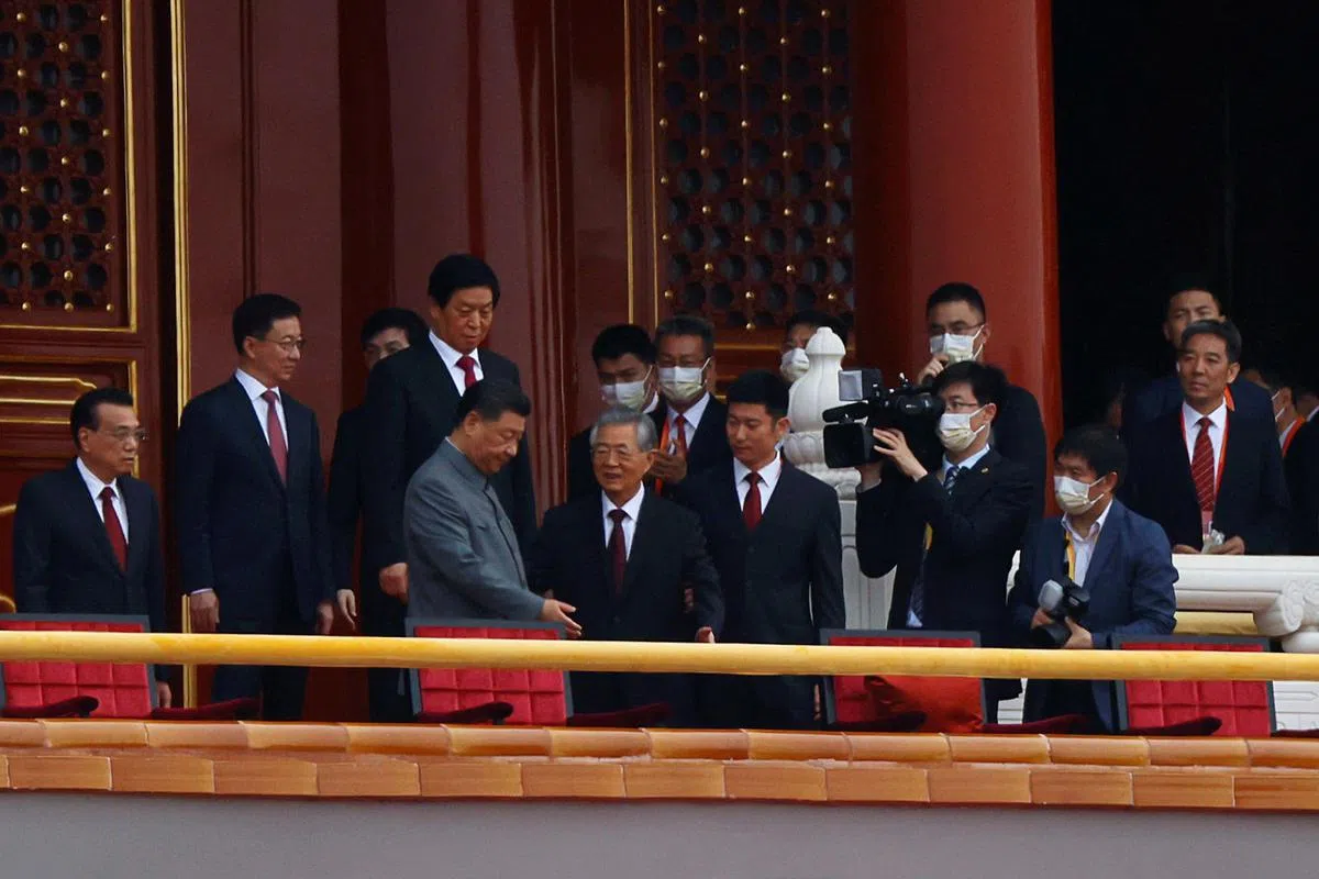 今年78岁的前中共总书记胡锦涛（前排左二）被工作人员搀扶入座。（路透社）