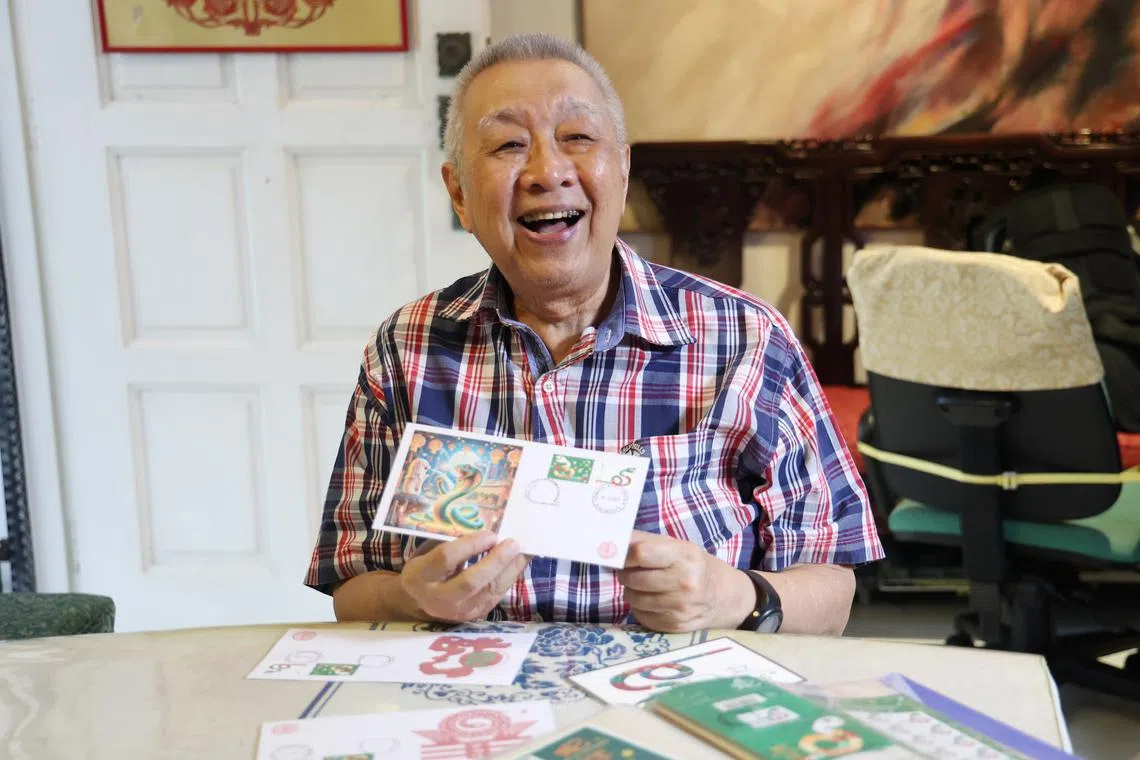 与时代并进，陈更生今年用AI软件设计蛇年首日封，他风趣地说：“青蛇来到新加坡拜访鱼尾狮了”。（翁铭芯摄）