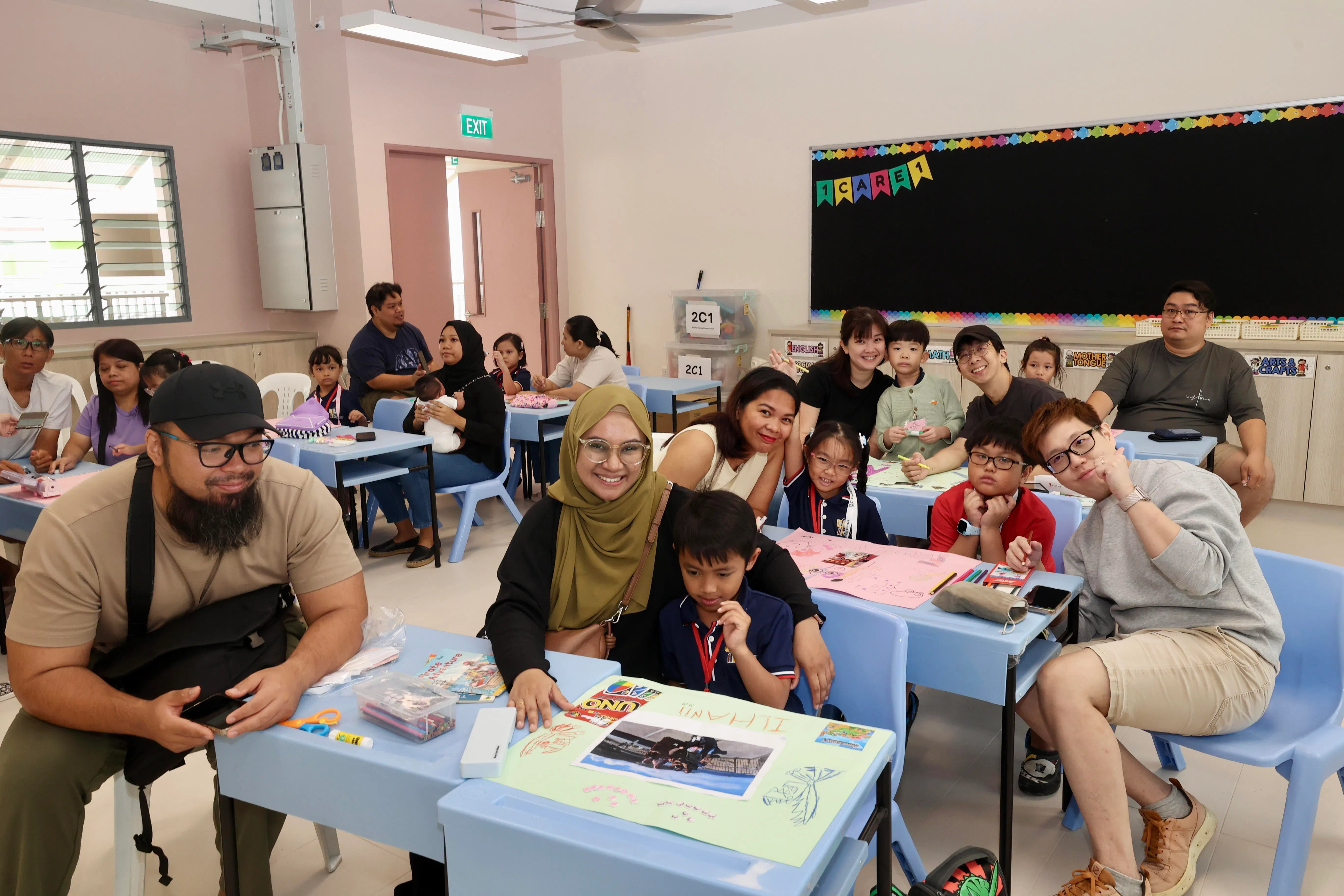 聚英小学安排家长与孩子一同进行亲子创作活动，利用个人照片等设计，点缀自己的桌子。（邝启聪摄）