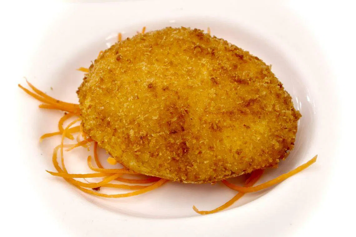 海鲜酿蟹盖以带子粒、洋葱、蟹肉、干贝等丰富食材组成。（特约陈来福摄）