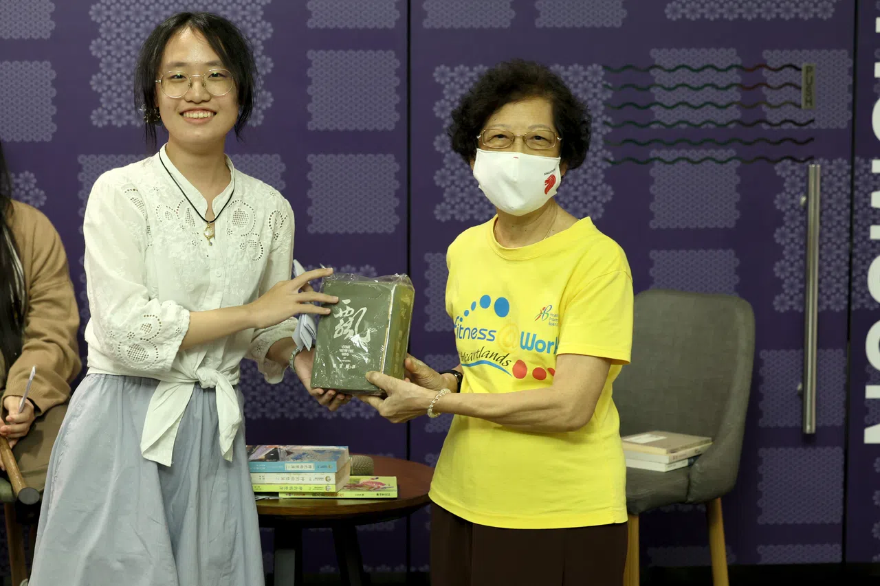 学生通讯员洪湘婷（左）成功标得黄女士收藏半世纪的《飘》。（龙国雄摄）