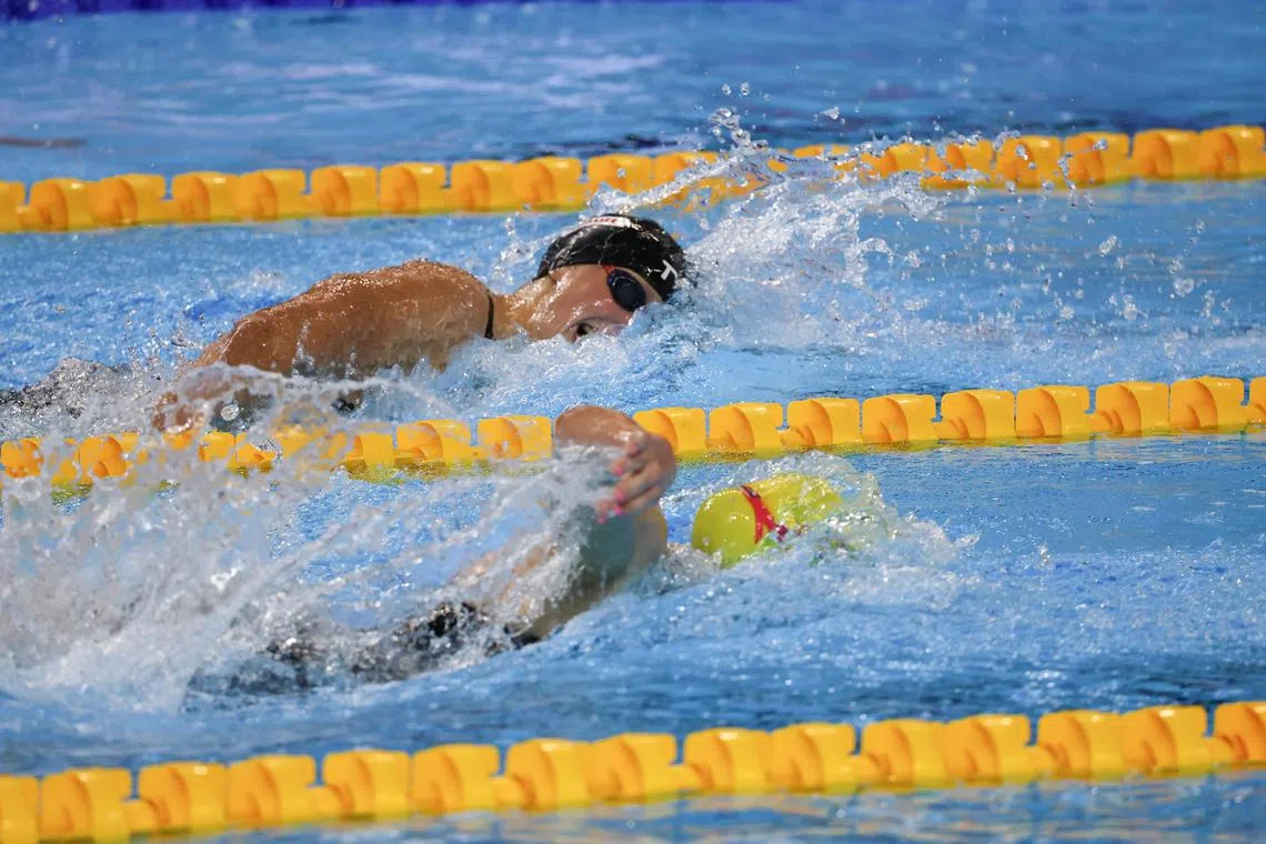 凯蒂（黑帽）和拉妮（黄帽）在比赛中于相邻的泳道较劲。（关俊威摄）