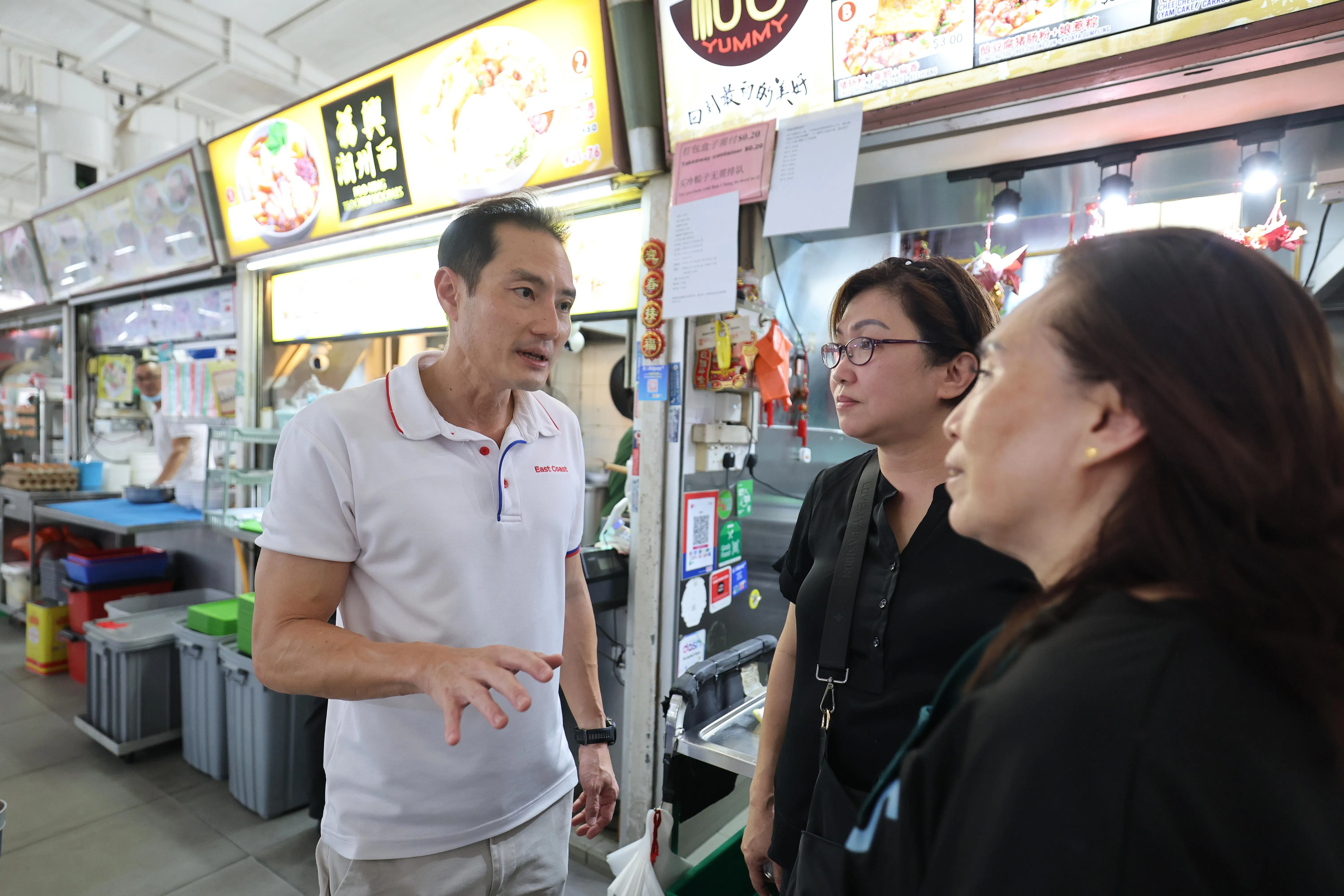 东海岸集选区议员陈杰豪（左一），星期六下午到勿洛北第216座巴刹与熟食中心用餐，以行动向居民说明只要做好基本预防措施，无须刻意避开巴刹、小贩中心等社区空间和日常活动。他也同小贩交谈，了解他们的情况。（唐家鸿摄）