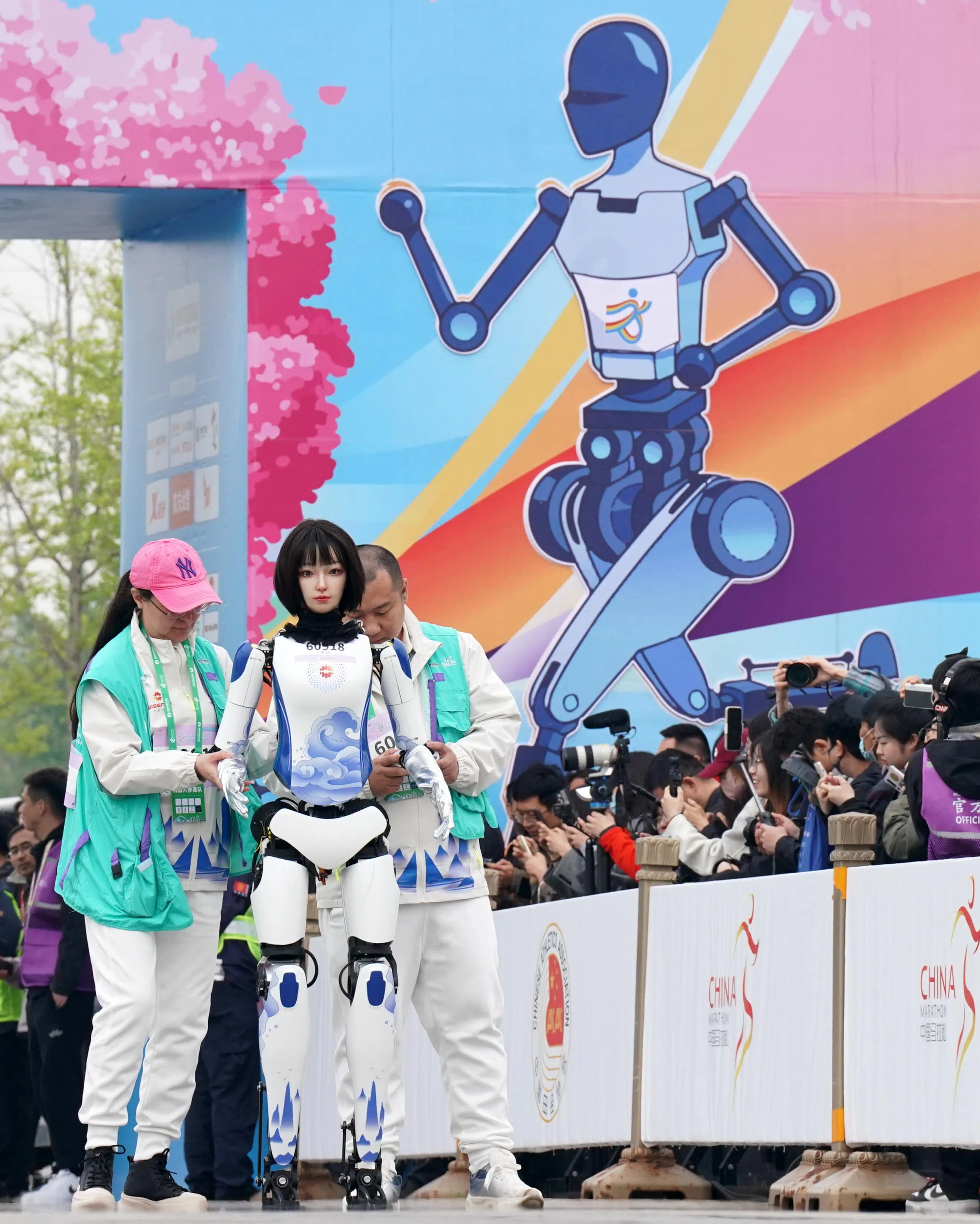钢宝队选手幻幻机器人（中）宣称外形酷似人类女性，并且能够眨眼和微笑。图为幻幻机器人在比赛中。（新华社）