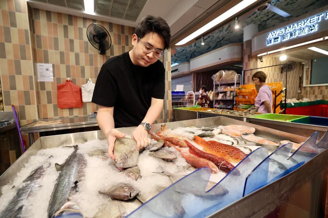 除了摆摊，蔬菜和海鲜摊老板欧映成，也同父亲在网上和电商平台售卖海鲜、蔬菜和猪肉。他们也供应马国猪肉给巴刹摊贩。（陈斌勤摄）