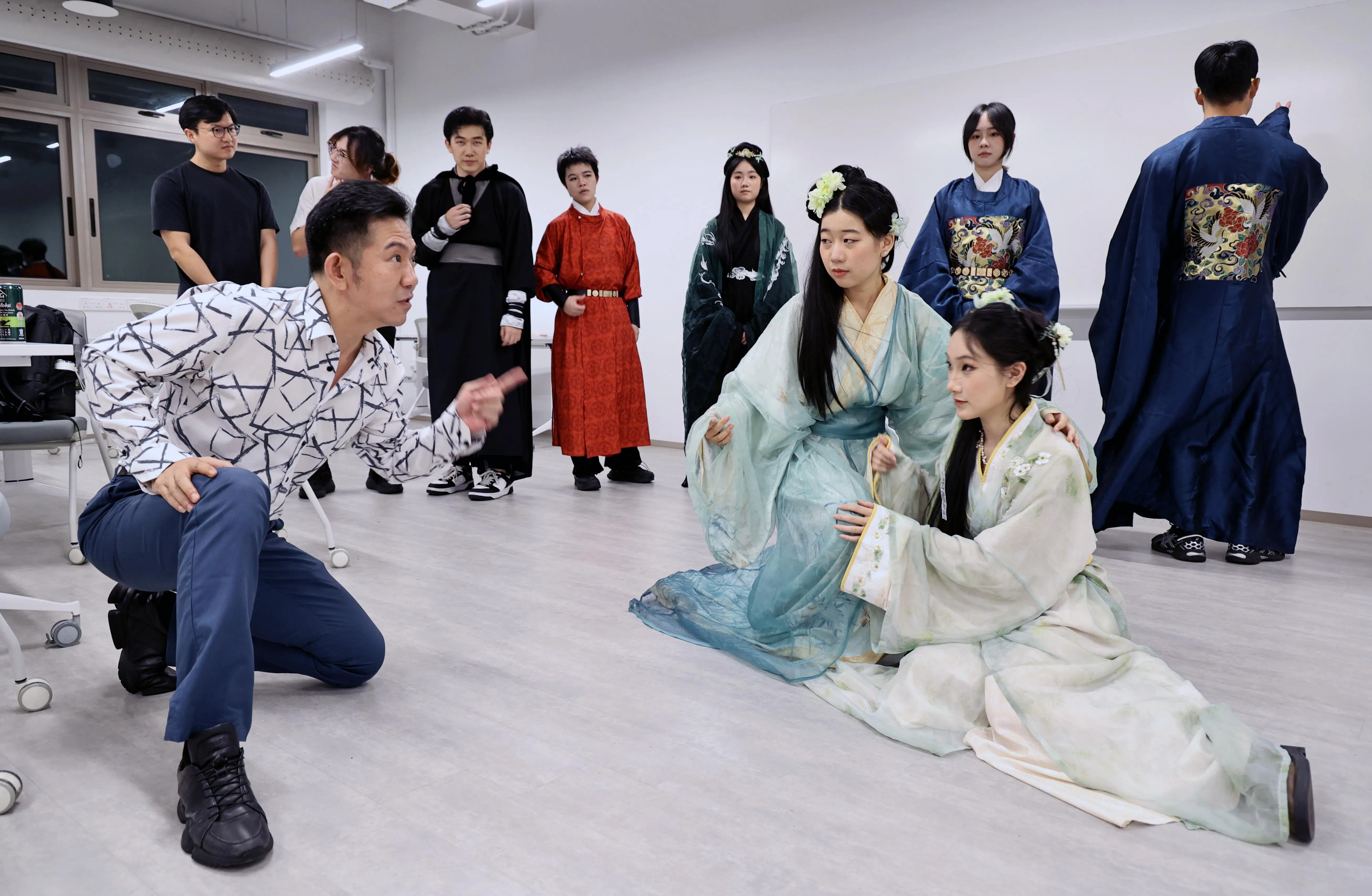 艺术指导老师王伟样（左）在彩排现场指导演员，反复调整表演细节。（周国威摄）