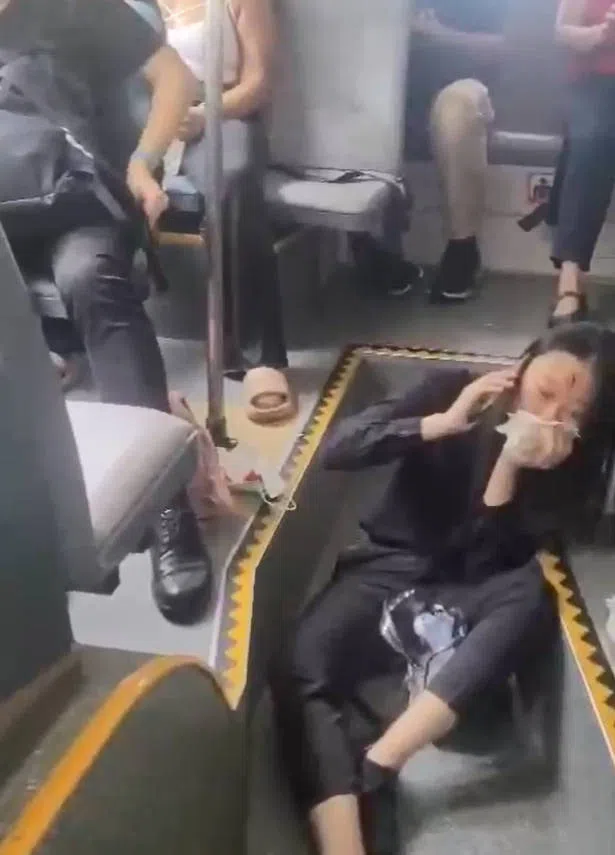 一名女乘客半躺坐在巴士的走道上，等待救护人员前来救治。（视频截图）