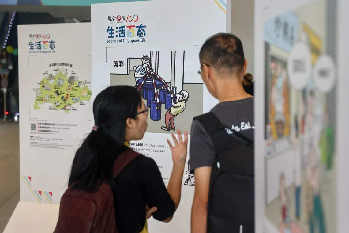 早报“生活百态”漫画展线上线下同步进行，图为公众榜鹅综合社区中心欣赏漫画并扫码了解漫画背后的故事。（陈渊庄摄）