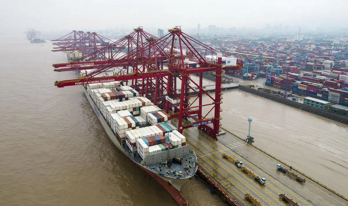 10月18日，在宁波舟山港北仑三期集装箱码头，一艘货轮在装卸货物。（新华社）