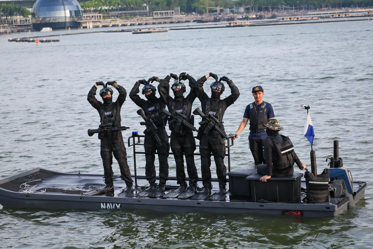 蛙人完成降落后，与滨海湾周围的公众互动。（张俊杰摄）