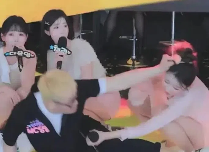 MC Ding Dong（左黑衣者）猛扯女主播头发，吓坏其他主播。（互联网）