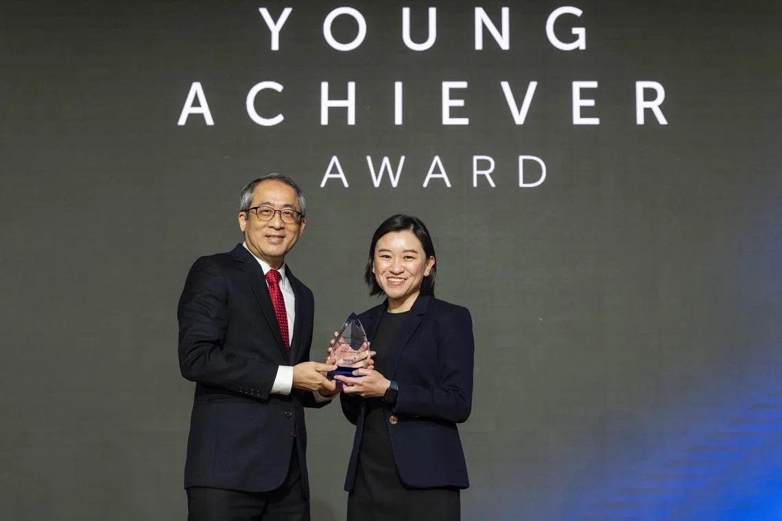 潘明美医生（右）从国大综合诊疗所总裁刘以仁客座副教授手中领取“年轻成就奖”。（国立大学医学组织提供）