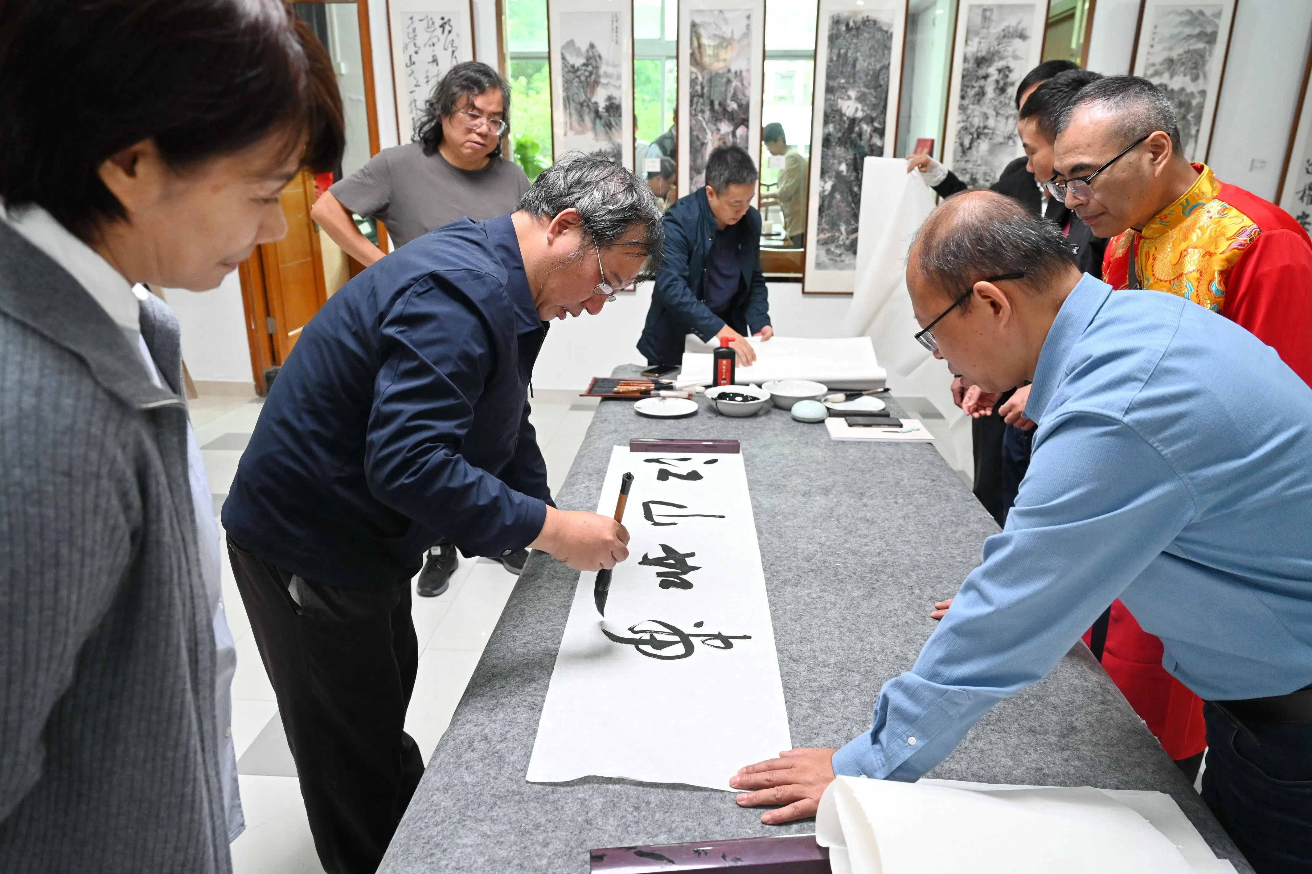 10月23日，福州市民在福州马尾职工之家纪念中国人民抗日战争胜利暨台湾光复80周年主题书画展现场开展交流活动。（新华社）