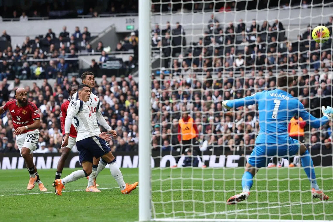 曼联前锋姆伯莫（左一）的这记头球攻门势大力沉，让热刺门将维卡里奥（蓝衣）无计可施。（路透社）