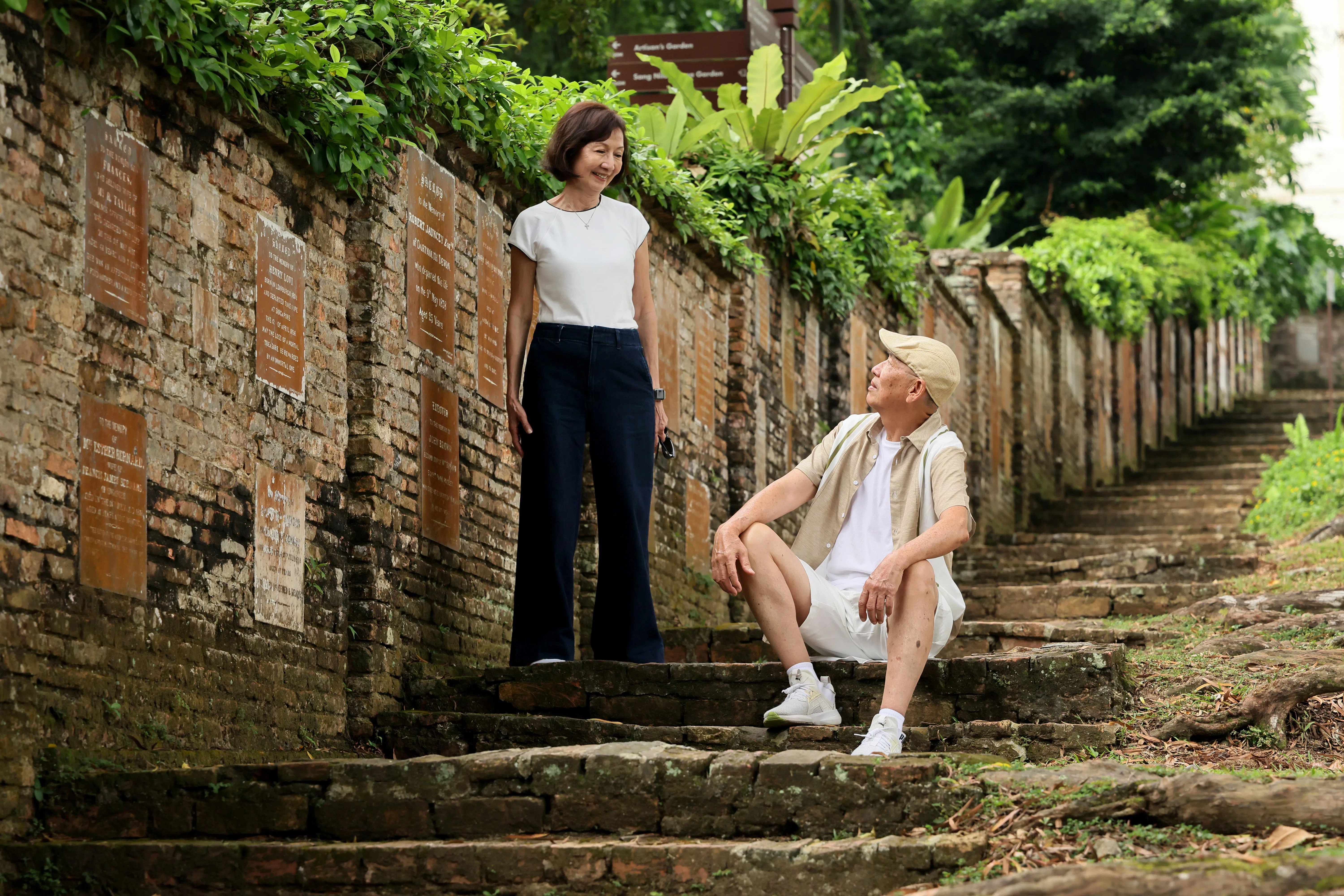 记者带两位男女主角重回1976年拍摄现场福康宁山老墙。（龙国雄摄）