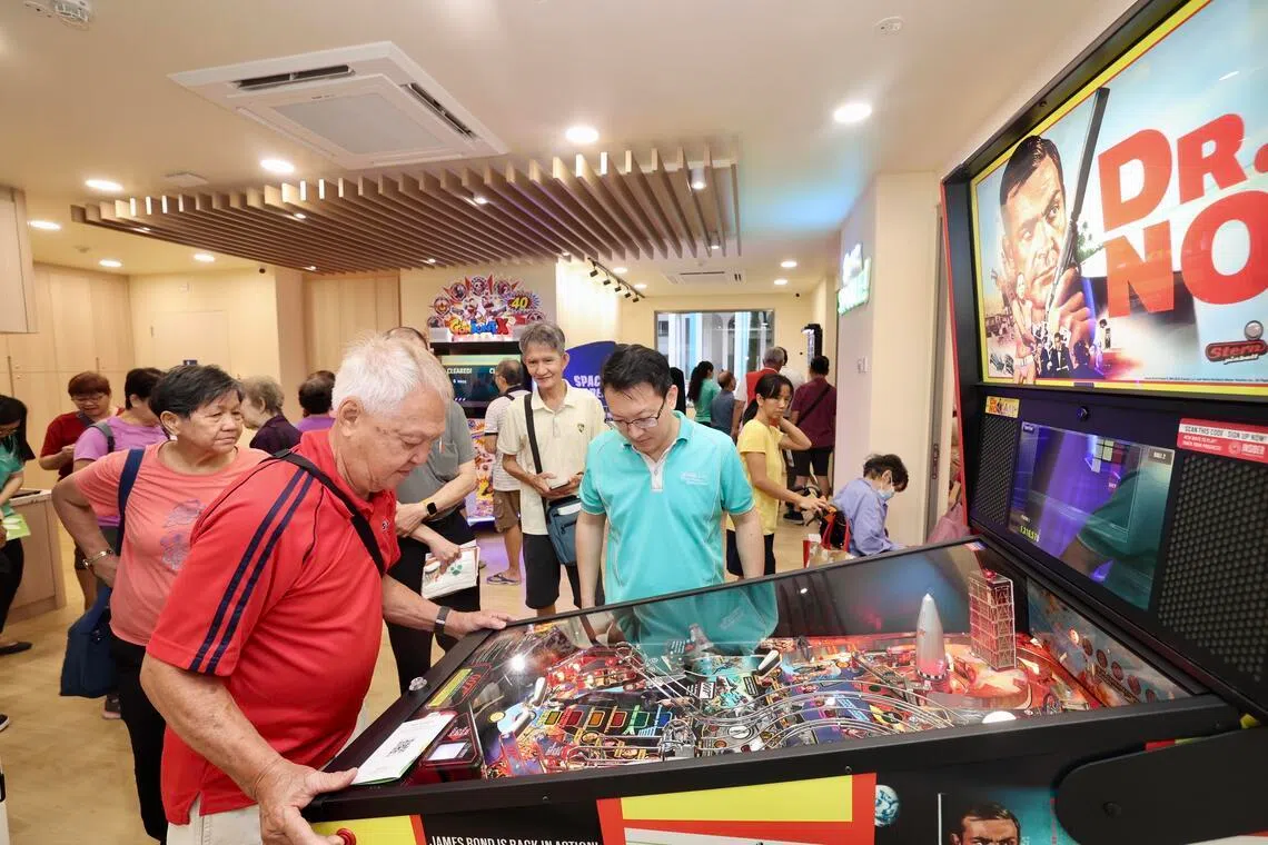 活跃乐龄中心有电玩游戏区，让年长者也能体验弹球机、飞镖等游戏的乐趣。（邝启聪摄）