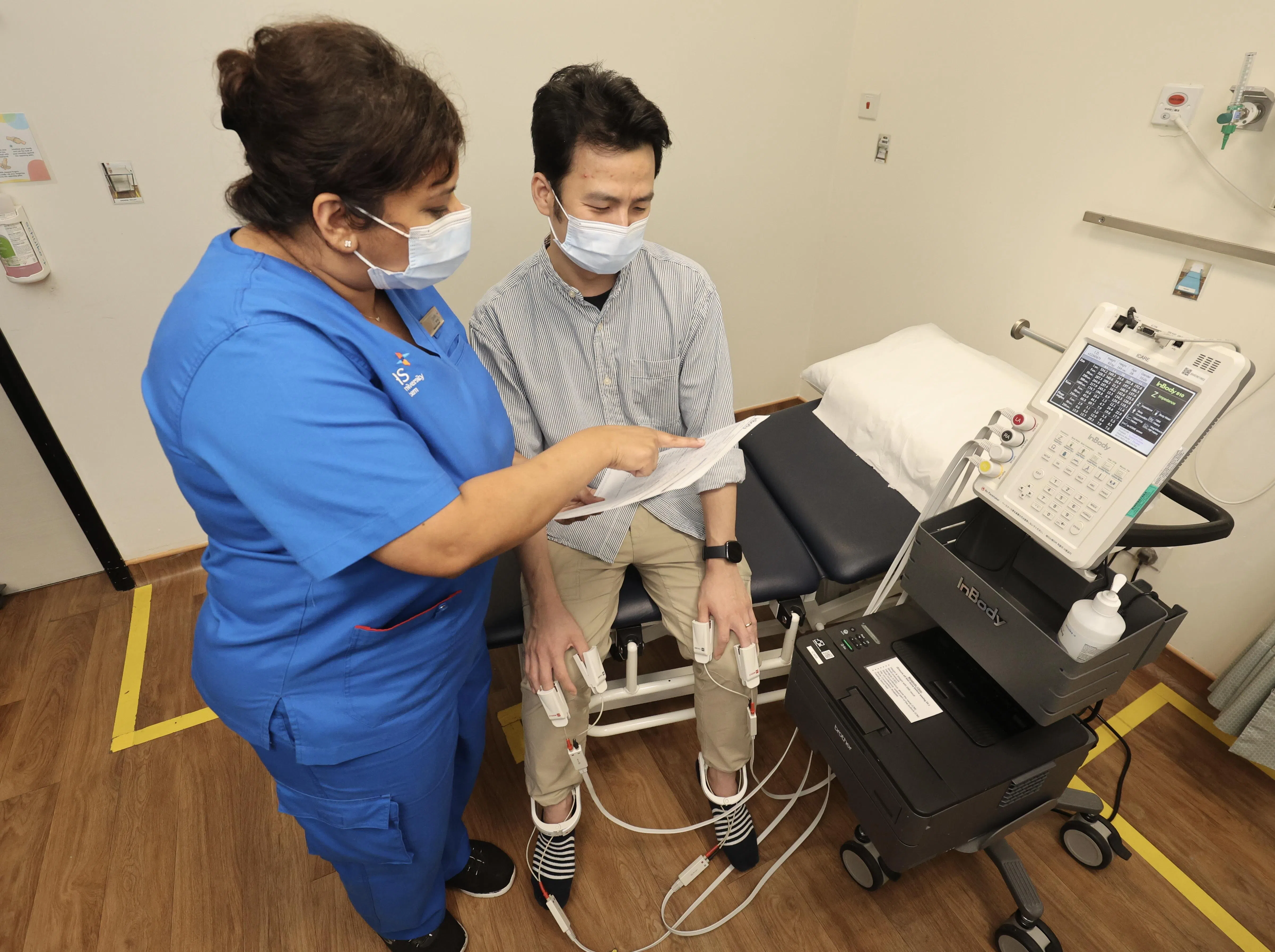 生物电阻抗分析仪器从参与者指尖读取各项数据，从而采集他的脂肪含量、体内水分、肌肉质量等重要身体指标。（邬福梁摄）