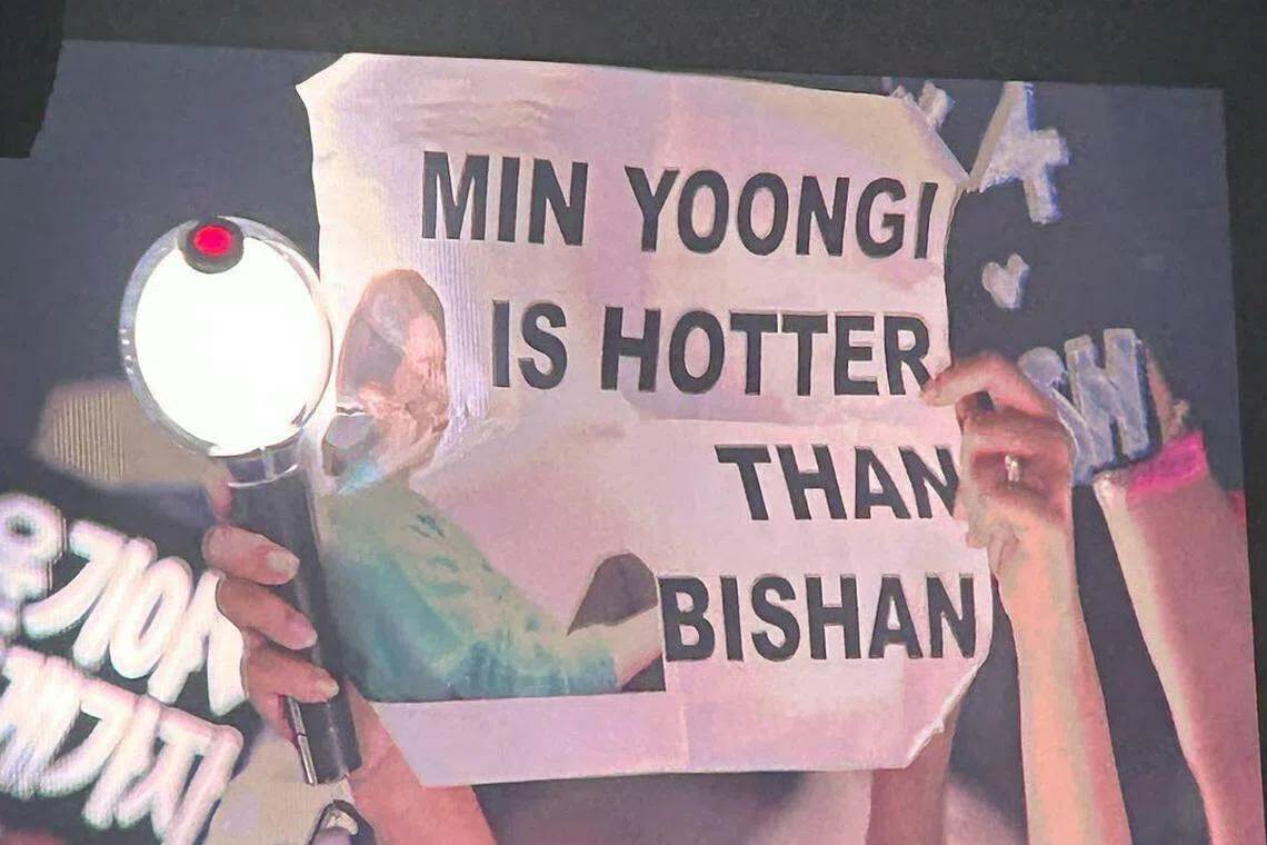 有粉丝高举写着“闵玧其比碧山还热”的偶像牌。（读者提供）