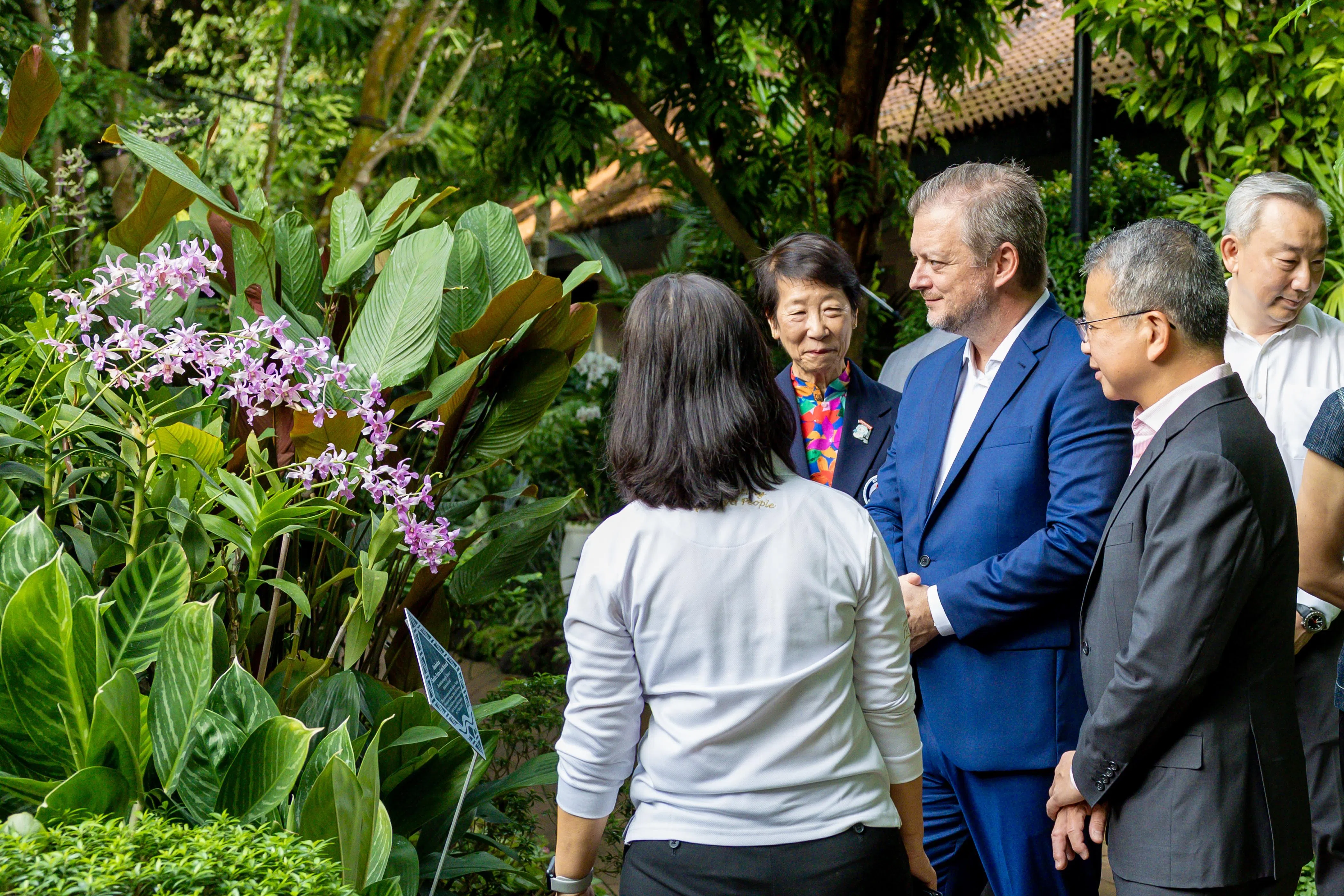 国际残奥委会主席帕森斯（蓝衣）在律政部长兼内政部第二部长唐振辉（右二）、新加坡全国残奥理事会主席张许淑敏博士（左二）等人陪同下，参观国家胡姬园。（新加坡全国残奥理事会提供）