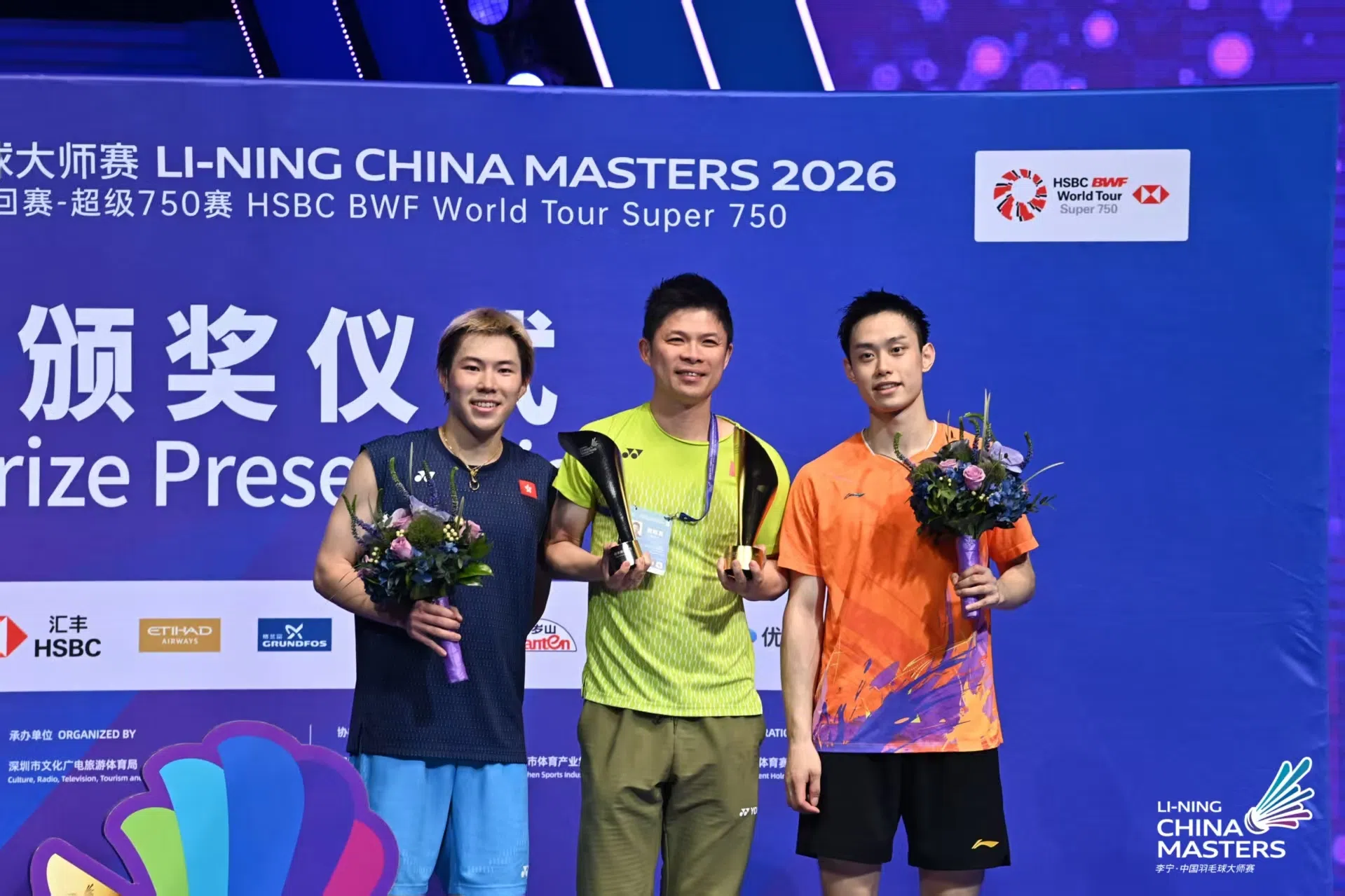 香港包办男单决赛，马来西亚教练黄综翰（中）功不可没，在颁奖台上和吴英伦（右）及李卓耀合影。（中国羽毛球大师赛提供）