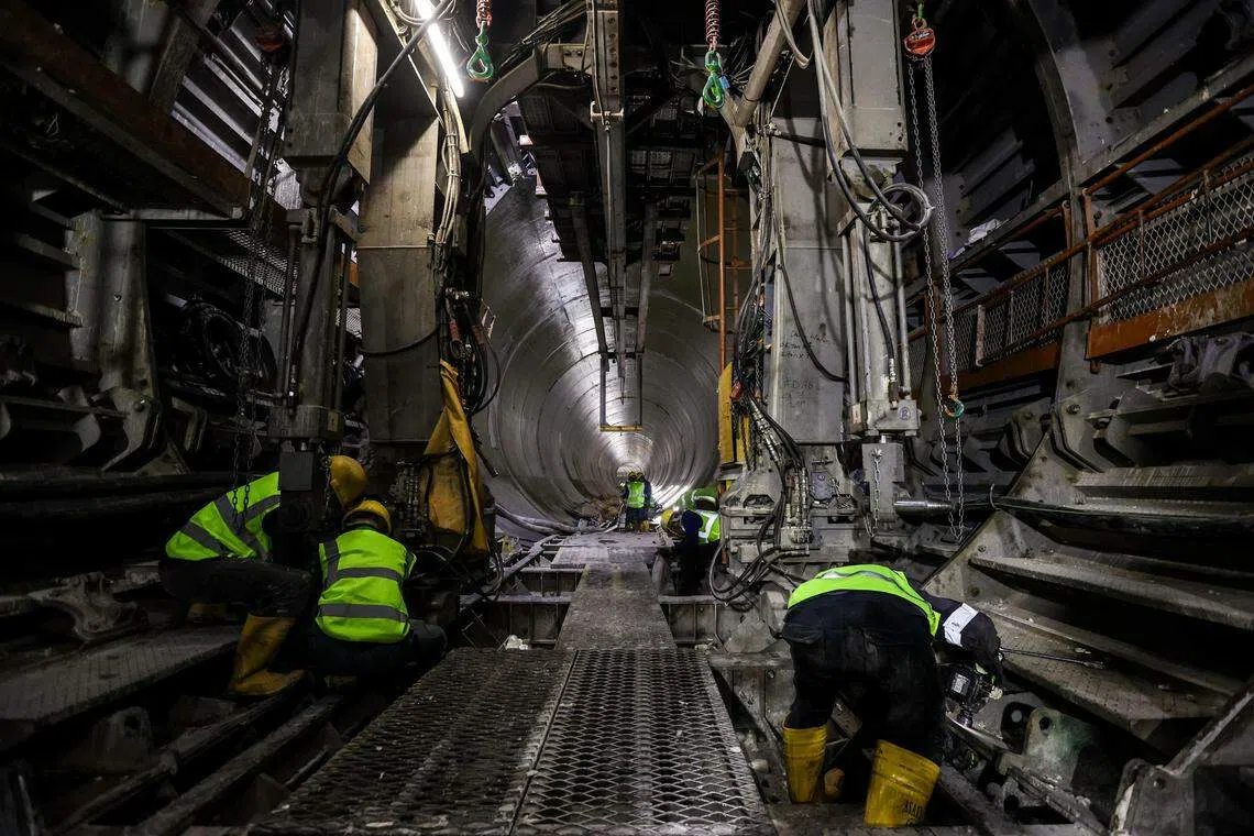 在潮湿炎热的环境下，来自他乡的工人辛勤工作，用高密度聚乙烯混凝土为隧道加工，避免隧道在潮湿和多微生物的环境下腐蚀，延长寿命。工人轮班工作，分早上8时到晚上8时，以及晚上8时至早上8时，每一班有15人。（关俊威摄）