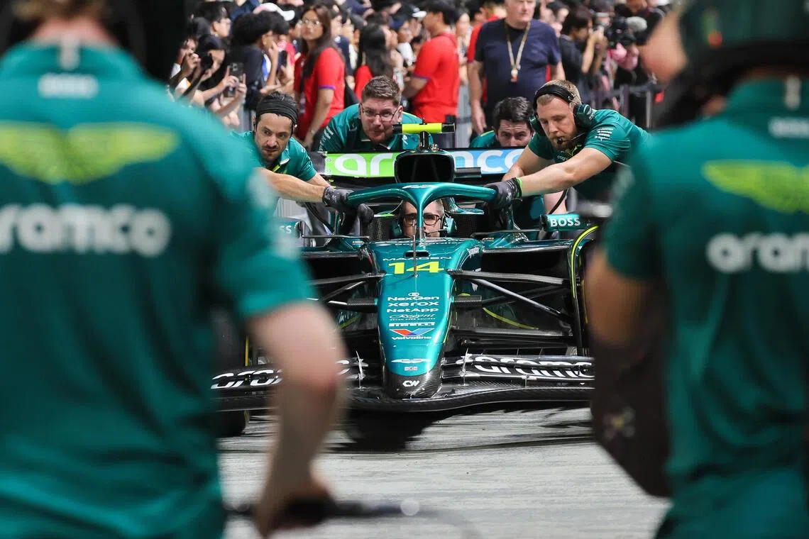 阿斯顿马丁的工作人员在车库前奋力推动赛车，为比赛做好准备。（张俊杰摄）