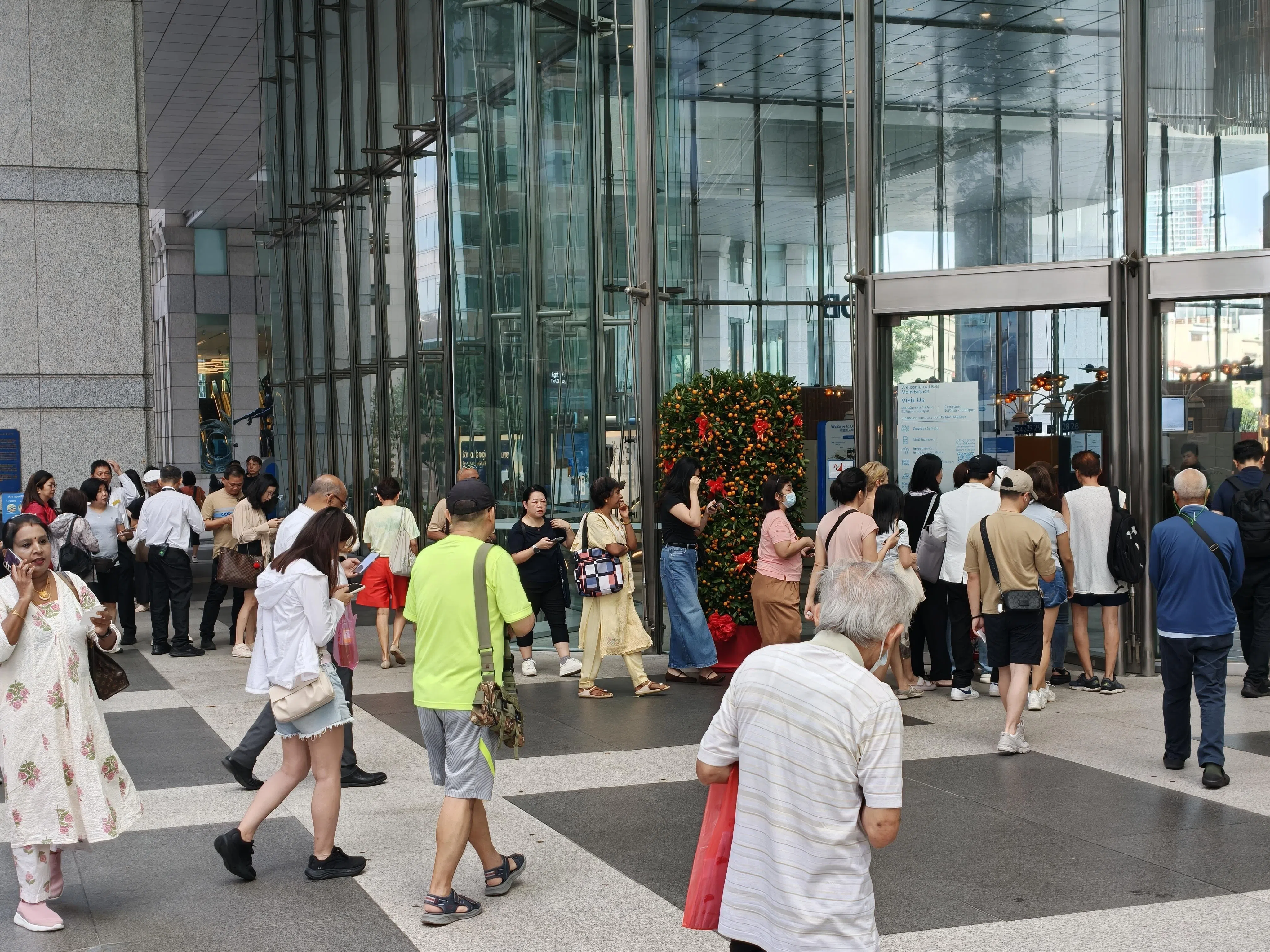 银行将不同业务的人流分开保持秩序。据观察，买金人流和换新钞的相比不遑多让。（何家俊摄）