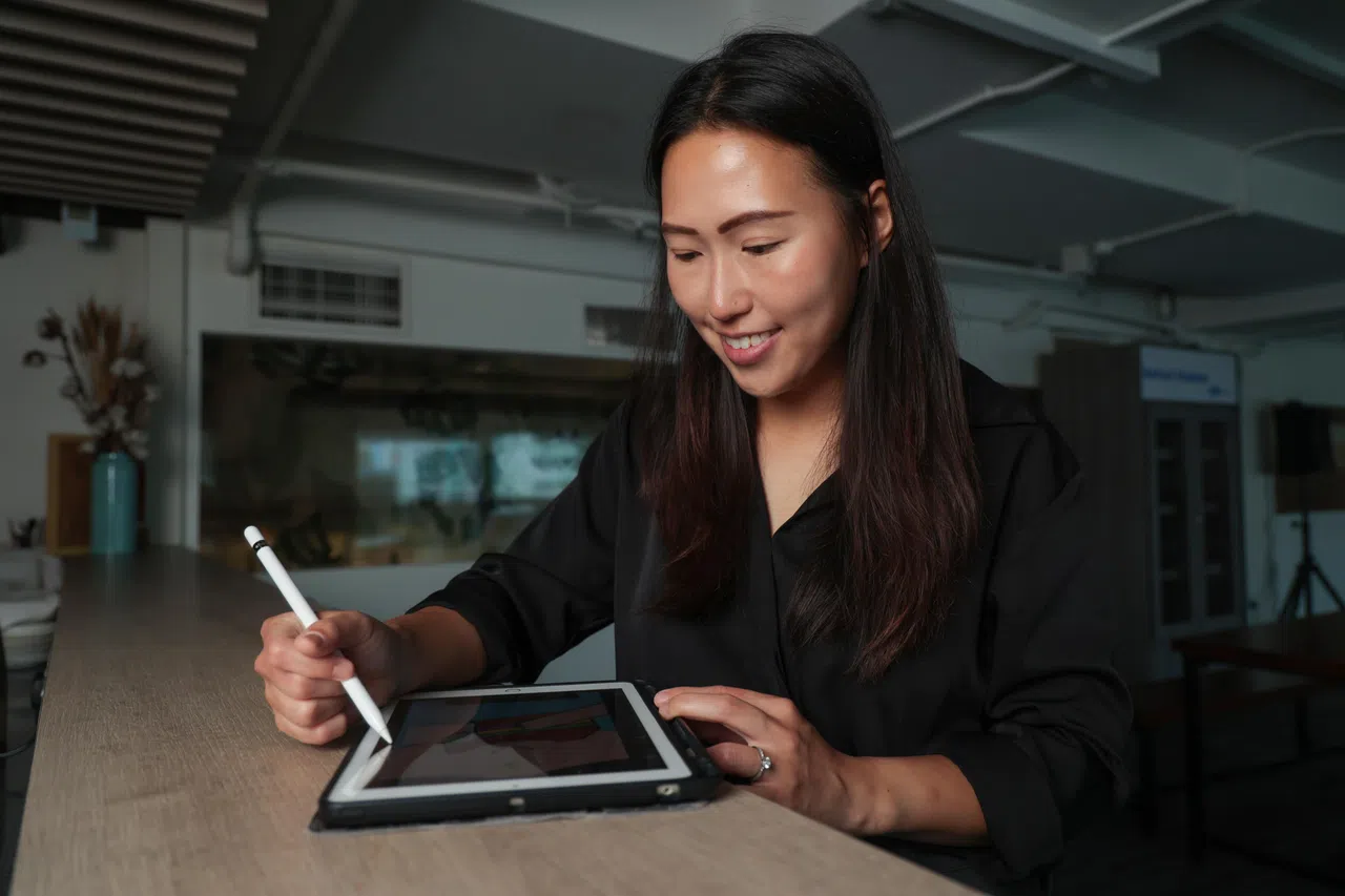 大学主修市场行销的冼慧媚，亲手绘出卡片上的创意设计，构思人物设定并编写玩法。（李冠卫摄）