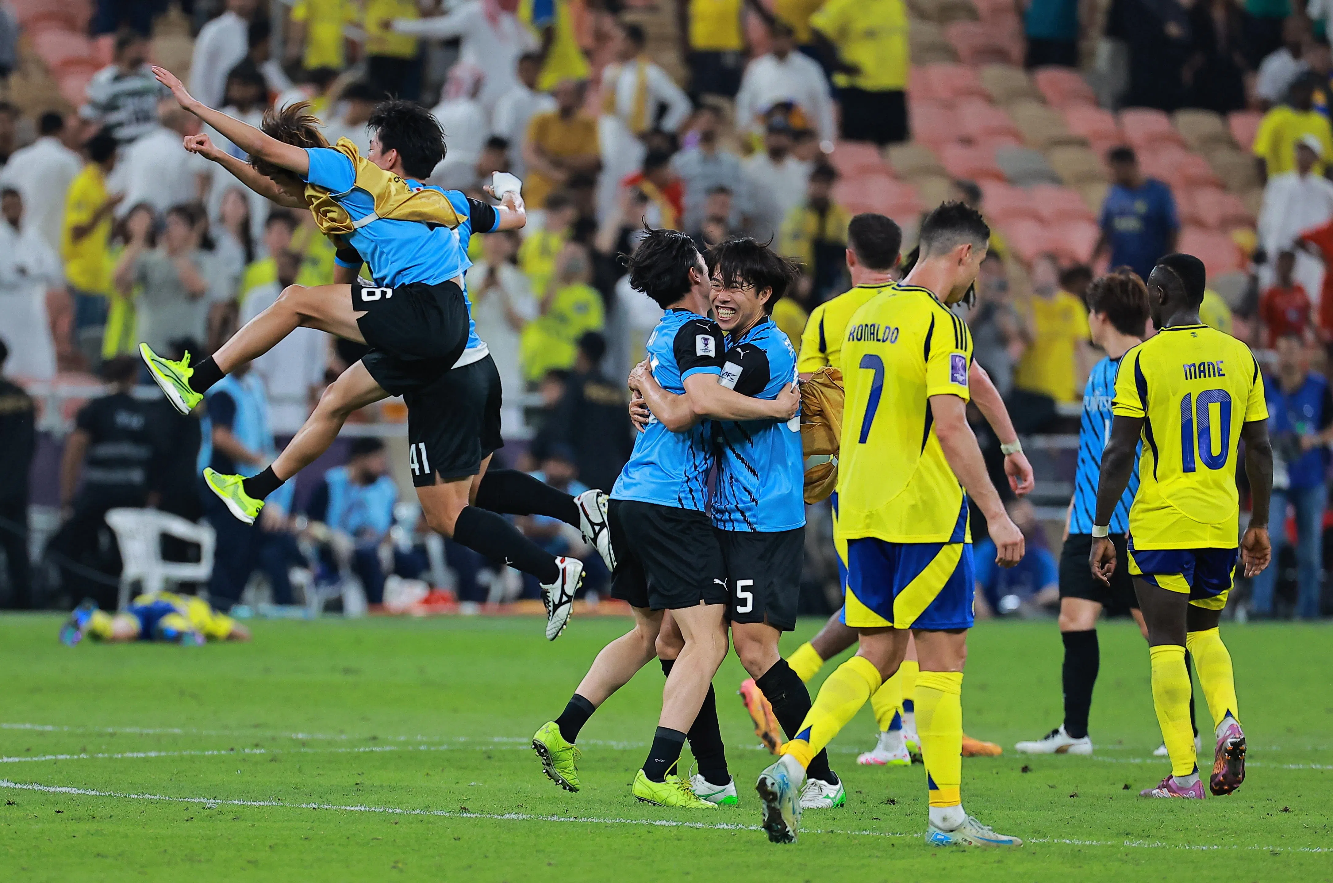 川崎前锋（浅蓝衣）球员赛后庆祝胜利，罗纳尔多（7号）从一旁黯然神伤地走过。（路透社）