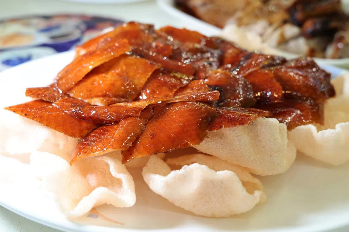 脆皮烤鸭连同蛋皮、黄瓜、葱白、炸虾饼及甜面酱一同吃，味道特别饱满。（梁麒麟摄）